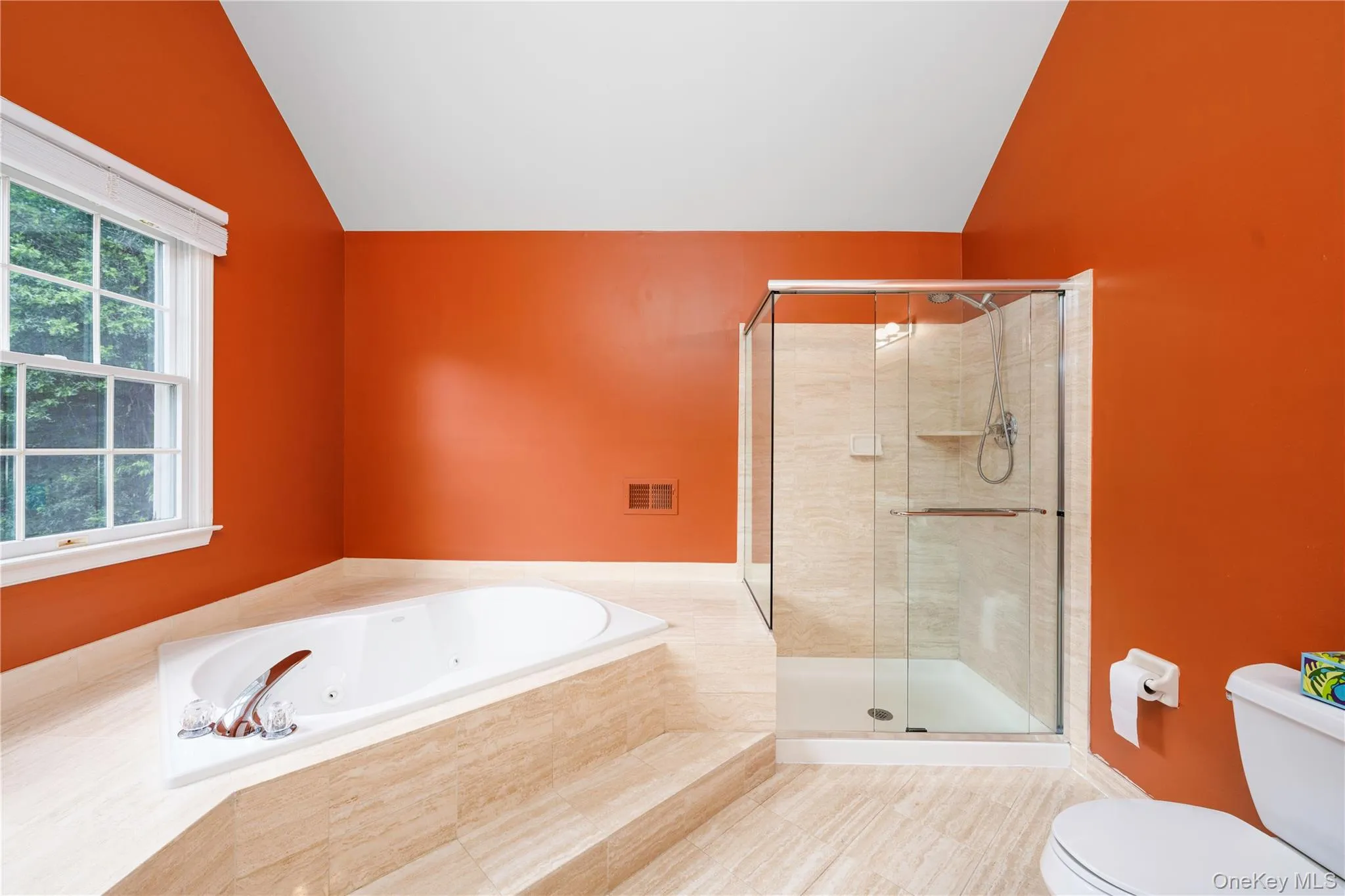Bathroom with vaulted ceiling, a jetted tub, a stall shower, and tile patterned floors Bathroom with vaulted ceiling, a jetted tub, a stall shower, and tile patterned floors