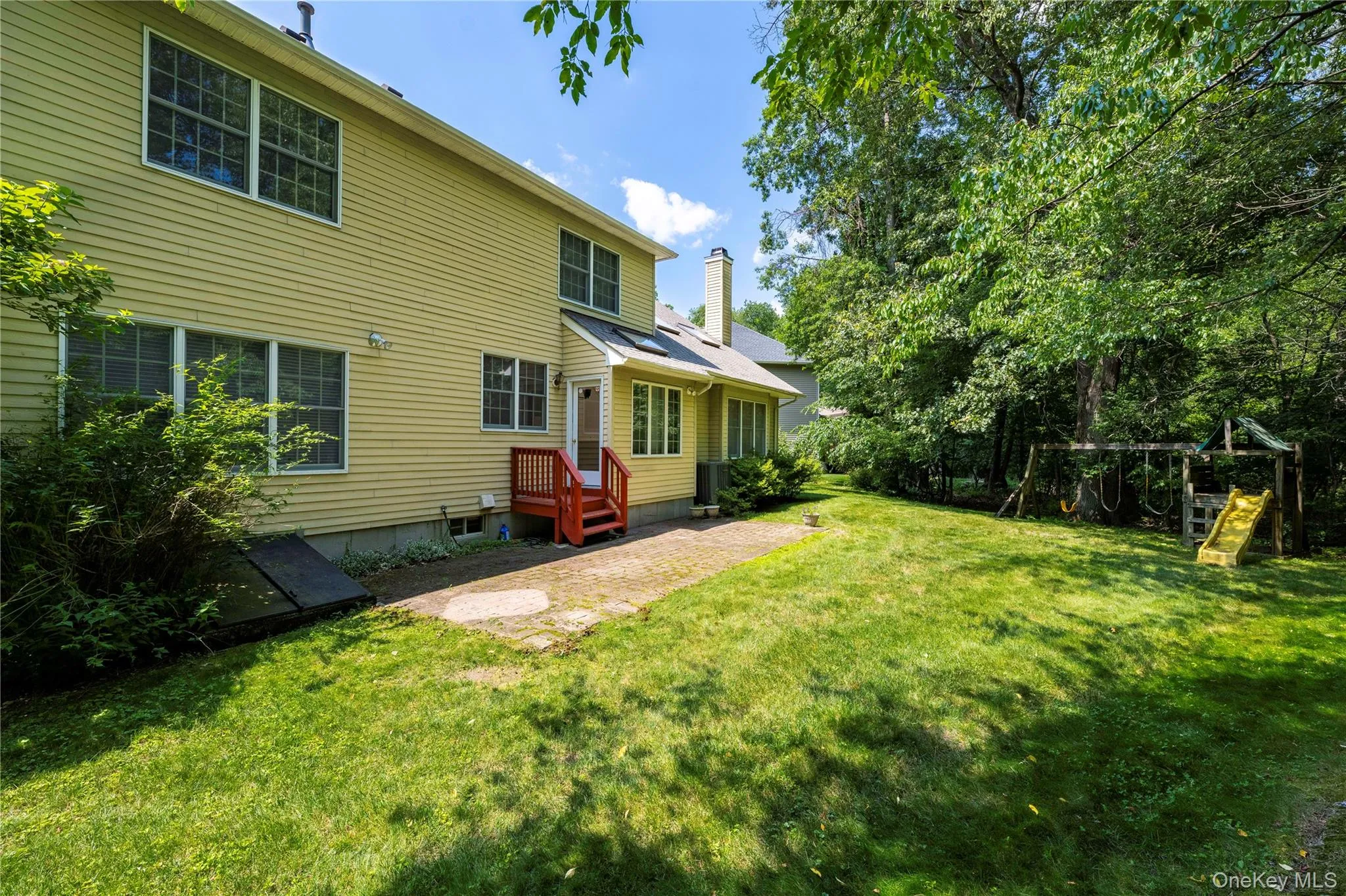 View of green lawn with a playground and a patio View of green lawn with a playground and a patio