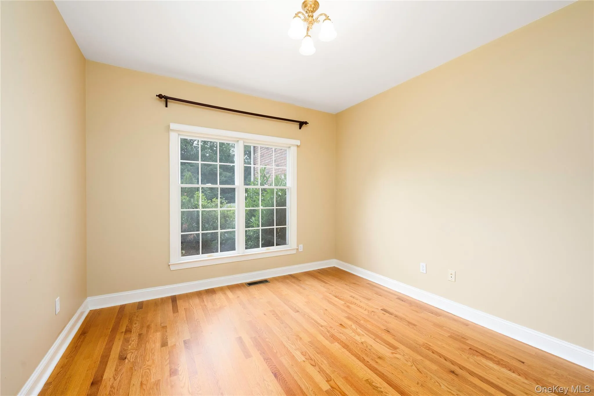 Spare room featuring light wood-type flooring and baseboards Spare room featuring light wood-type flooring and baseboards