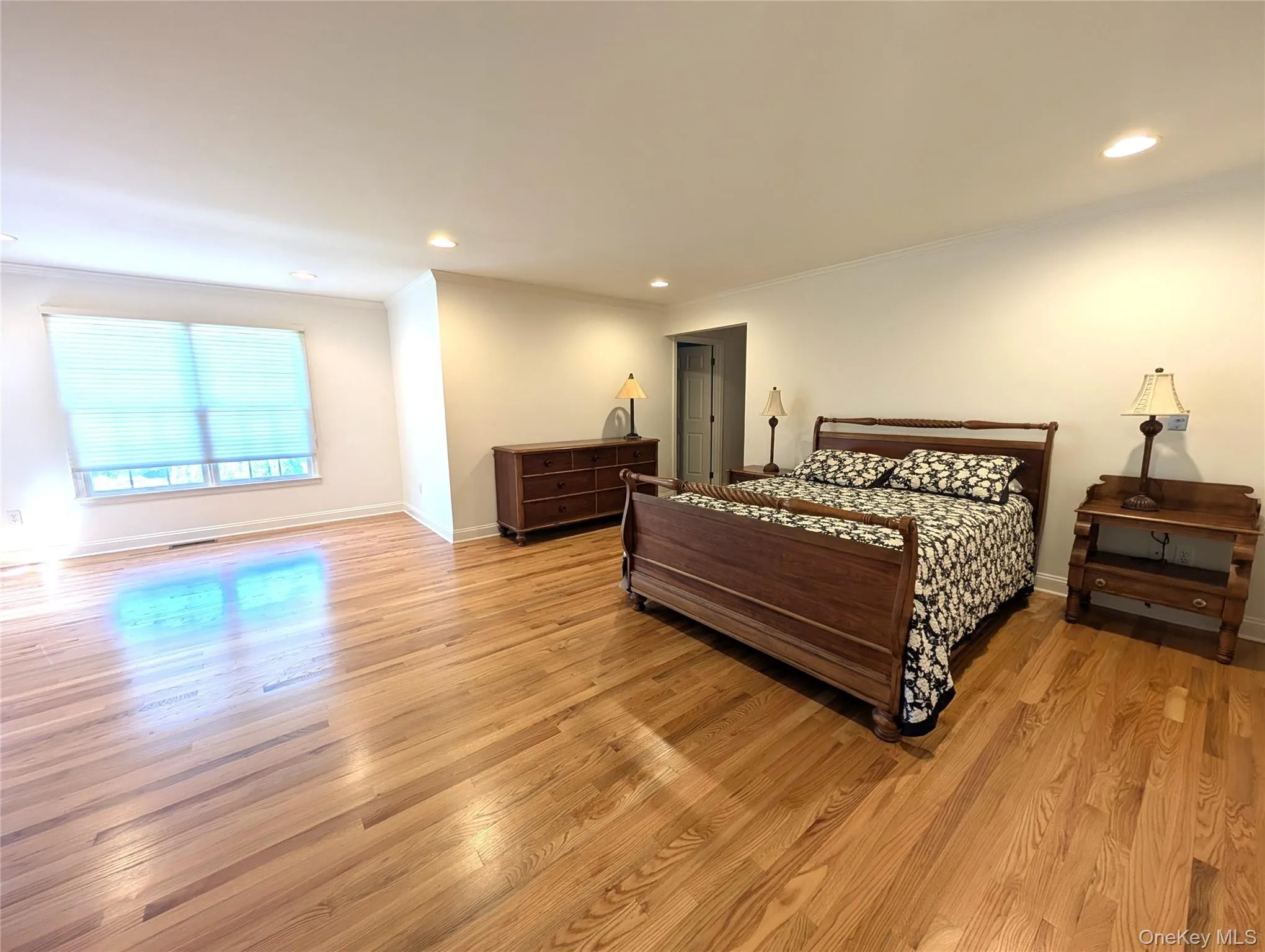 Bedroom featuring ornamental molding, recessed lighting, and light wood finished floors Bedroom featuring ornamental molding, recessed lighting, and light wood finished floors