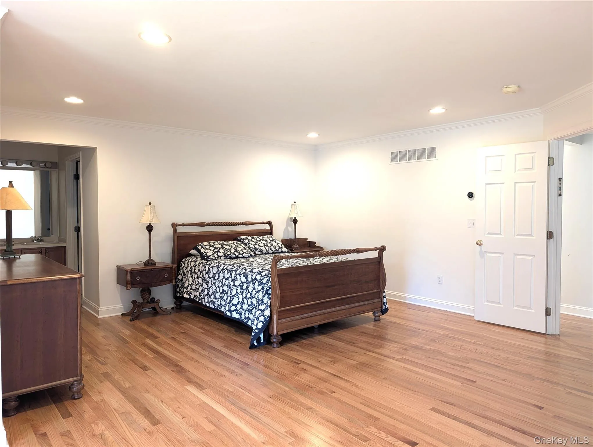 Bedroom with light wood-style floors, recessed lighting, and ornamental molding Bedroom with light wood-style floors, recessed lighting, and ornamental molding