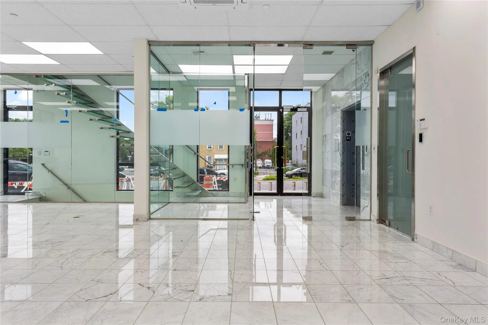 Unfurnished room with expansive windows, marble tiled floors, and a paneled ceiling Unfurnished room with expansive windows, marble tiled floors, and a paneled ceiling