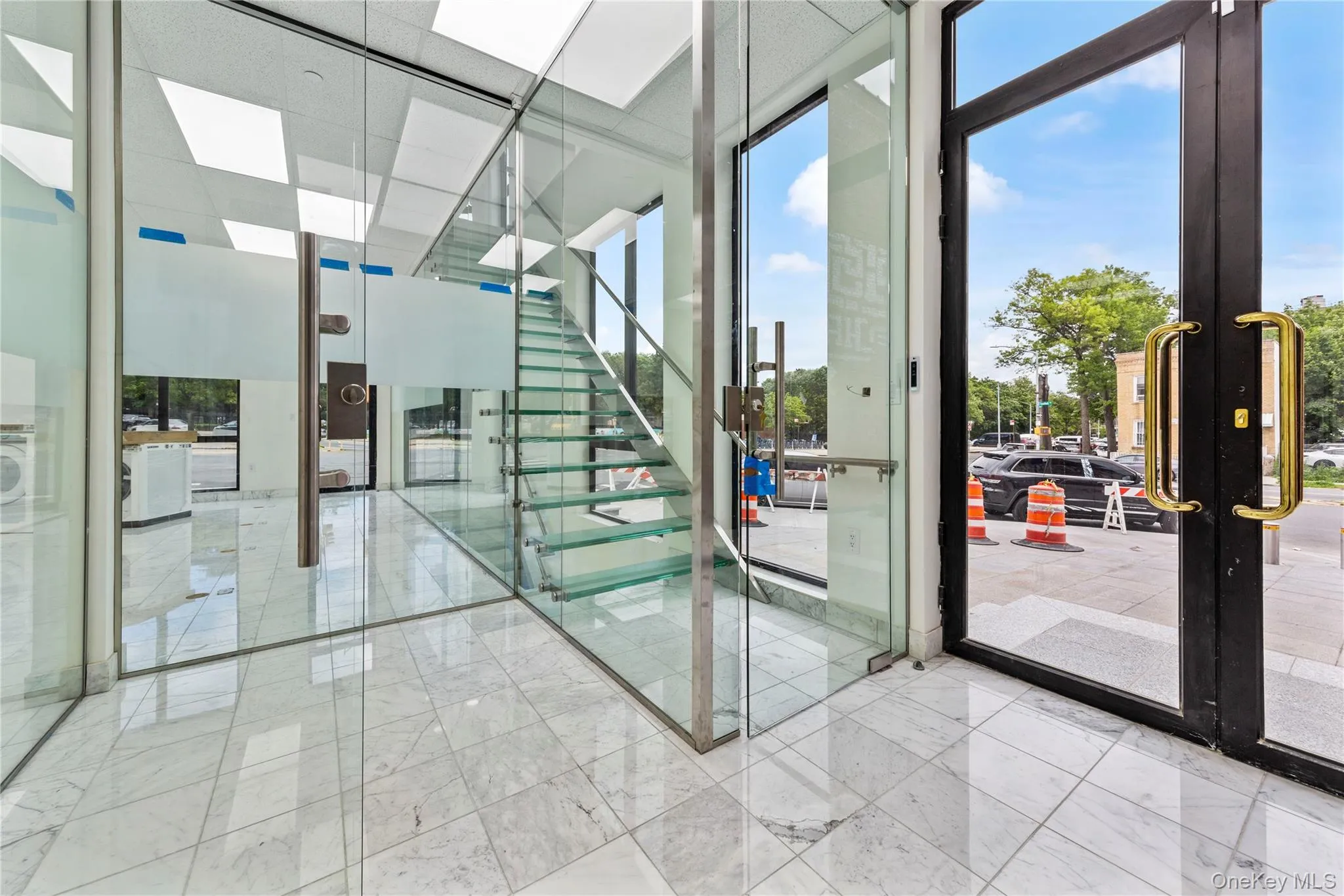 Stairway featuring expansive windows, french doors, and marble finish flooring Stairway featuring expansive windows, french doors, and marble finish flooring