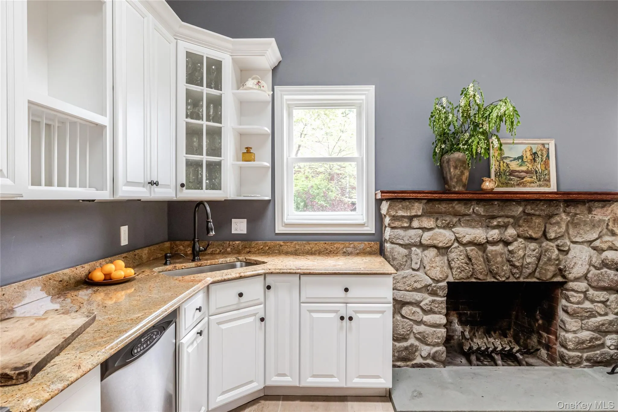 Kitchen with dishwasher, a sink, white cabinetry, and glass insert cabinets Kitchen with dishwasher, a sink, white cabinetry, and glass insert cabinets