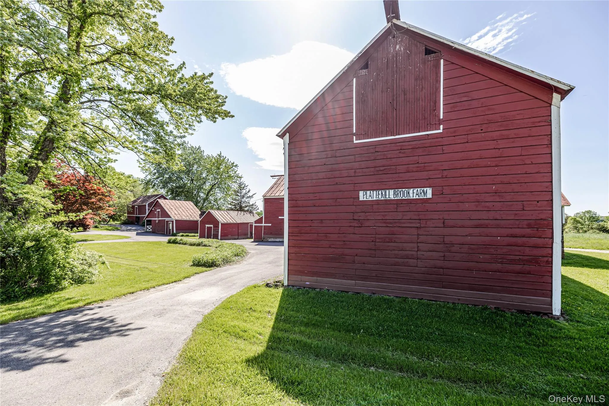 View of home's exterior with a barn, a lawn, an outdoor structure, and driveway View of home's exterior with a barn, a lawn, an outdoor structure, and driveway