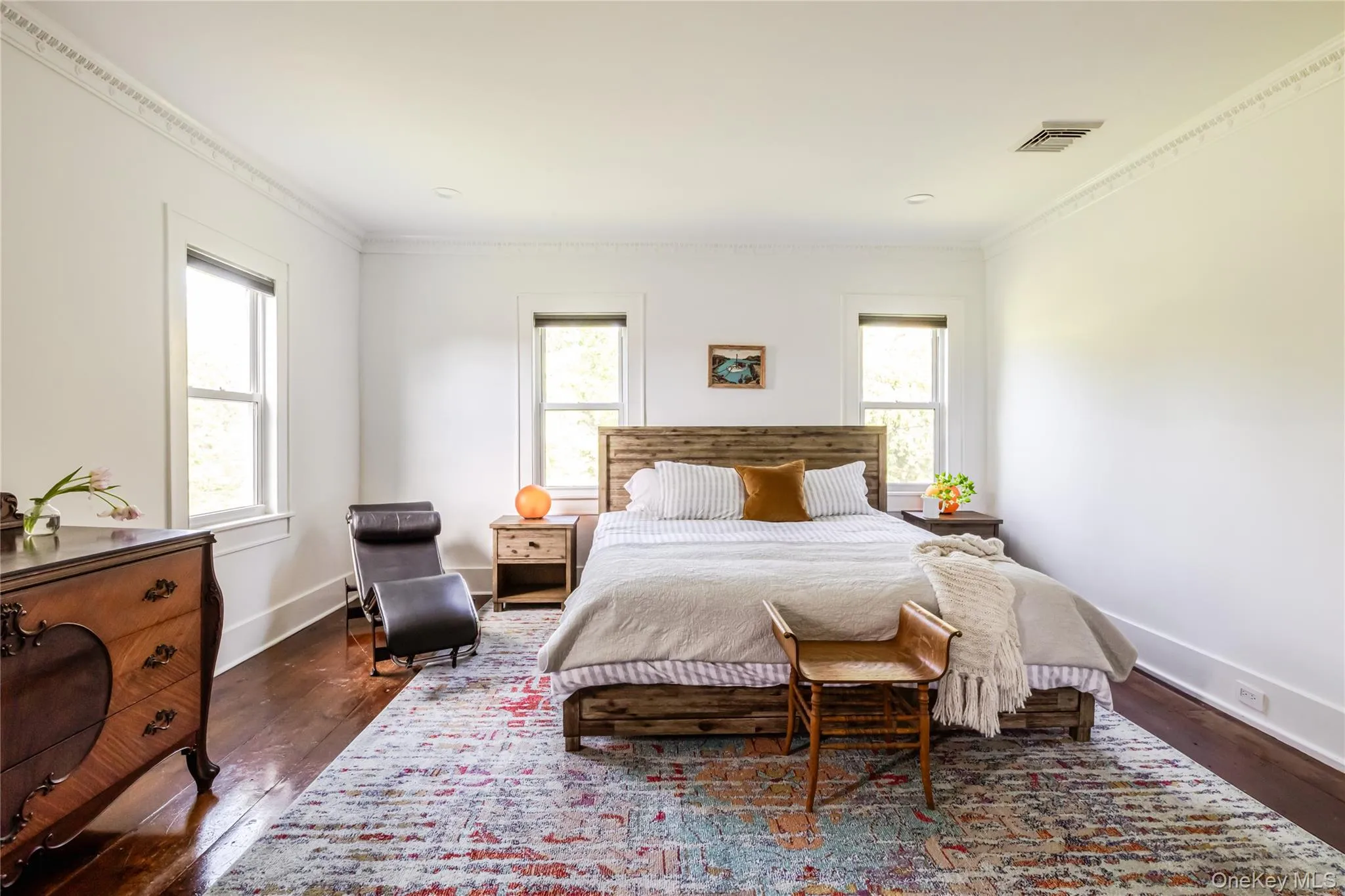 Bedroom featuring dark wood-type flooring, crown molding, and baseboards Bedroom featuring dark wood-type flooring, crown molding, and baseboards