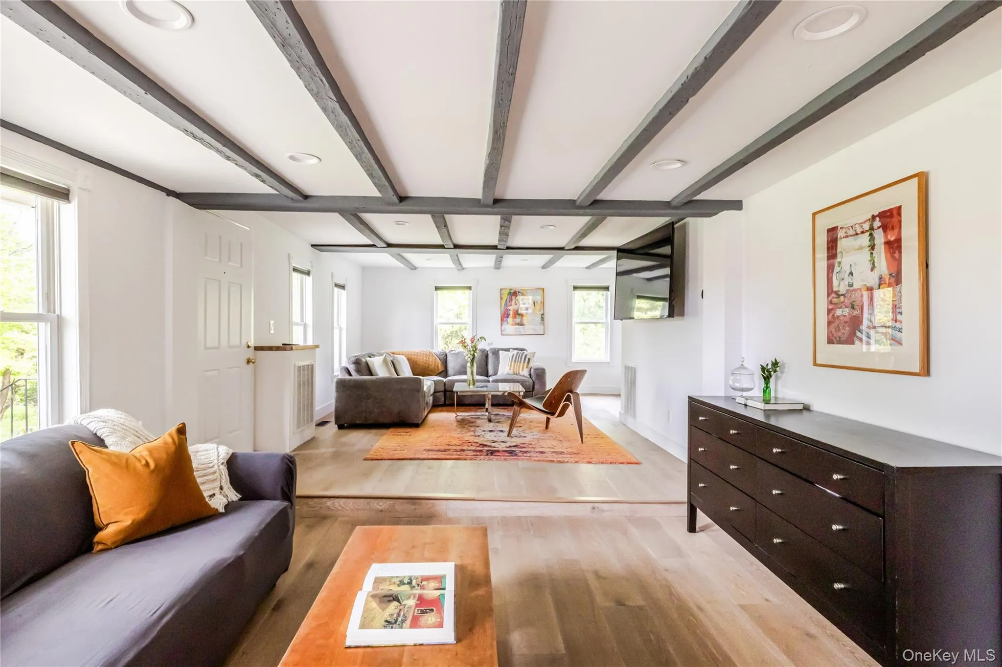 Living area with light wood-style floors, beamed ceiling, baseboards, and recessed lighting Living area with light wood-style floors, beamed ceiling, baseboards, and recessed lighting