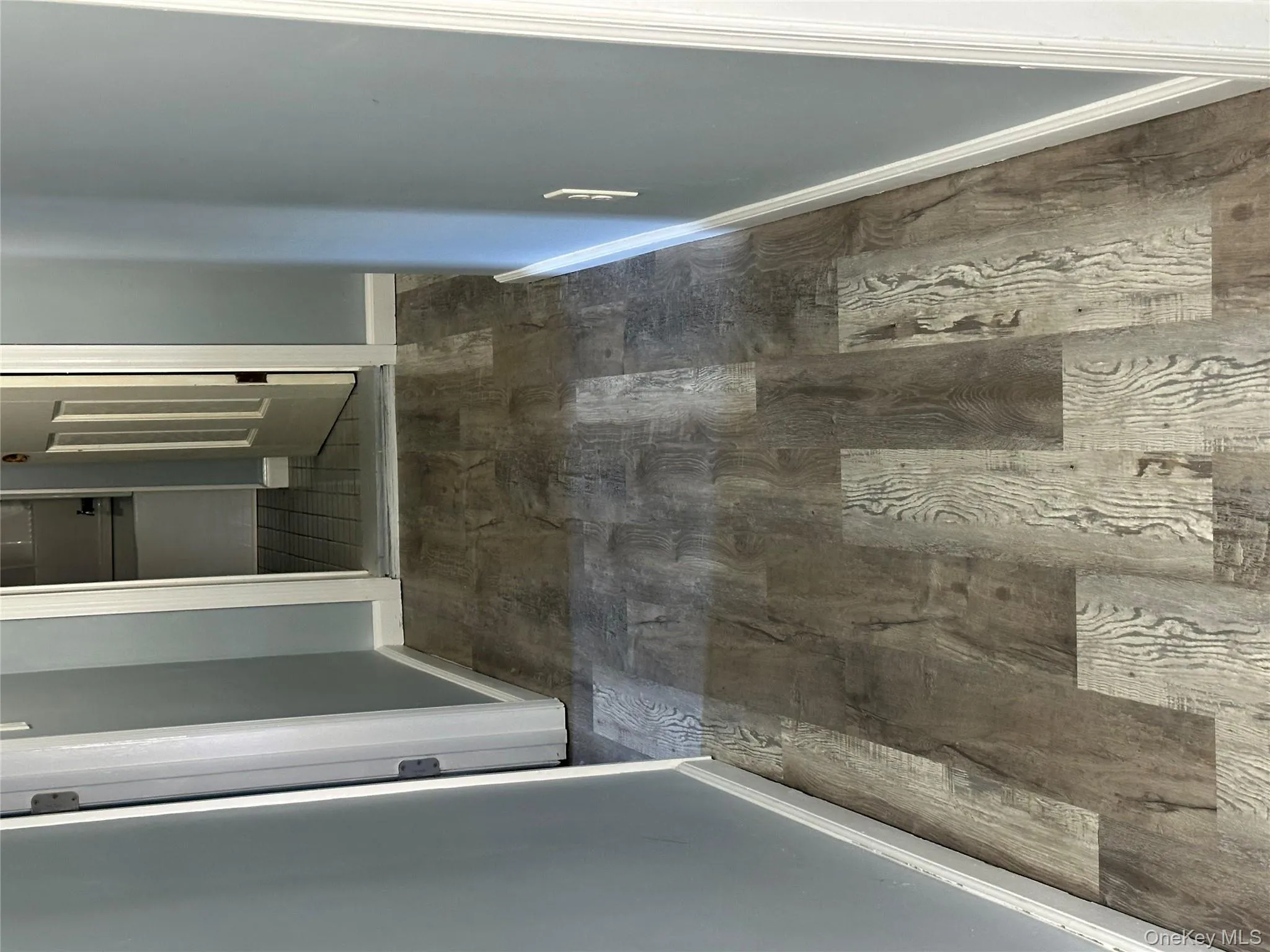 Hall with dark wood-type flooring and baseboards Hall with dark wood-type flooring and baseboards