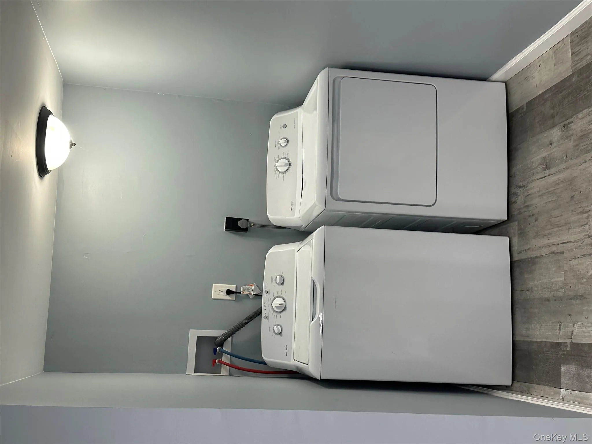 Laundry area with light wood finished floors and washing machine and dryer Laundry area with light wood finished floors and washing machine and dryer