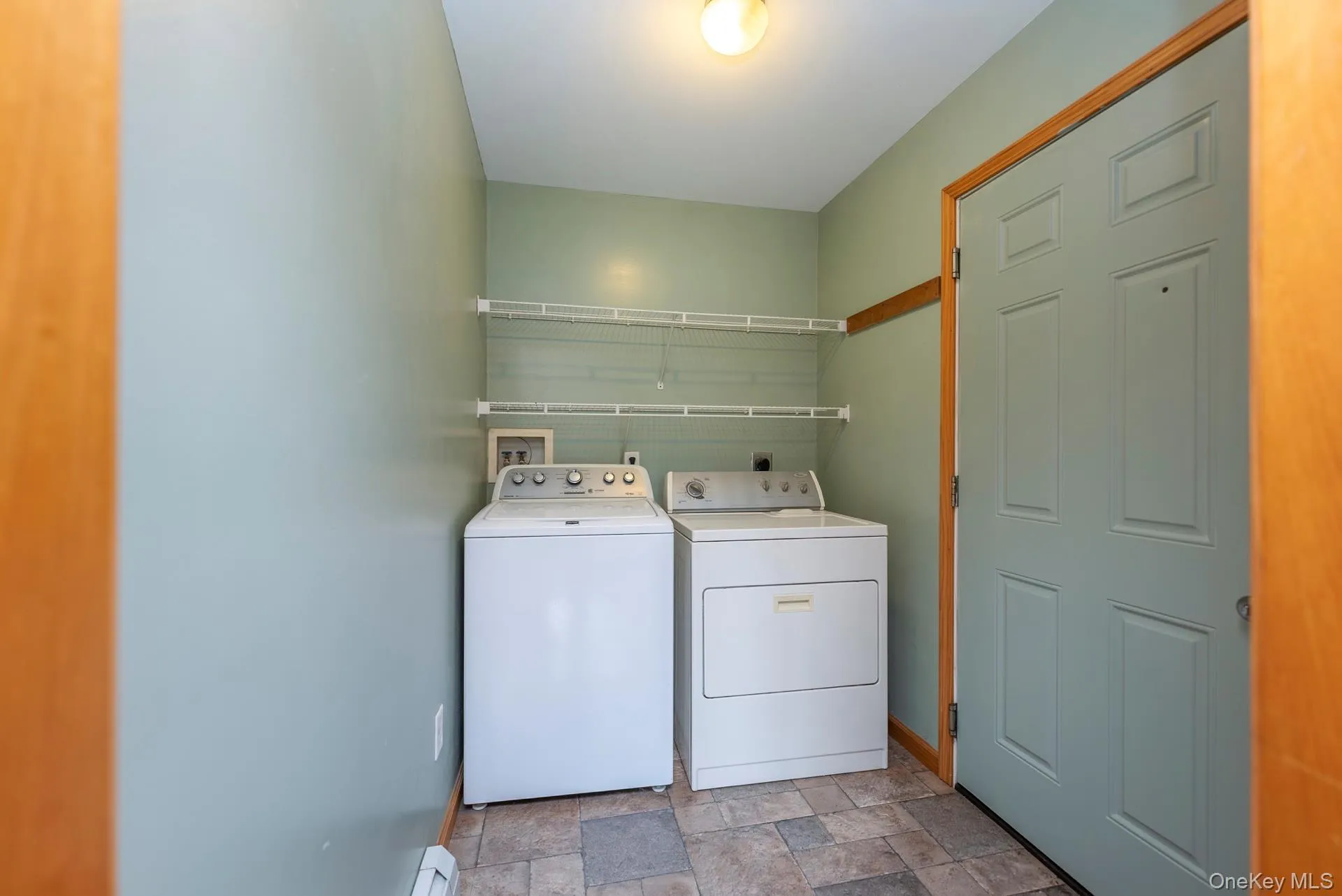 Laundry room featuring washer and clothes dryer, baseboards, and light stone finish flooring Laundry room featuring washer and clothes dryer, baseboards, and light stone finish flooring