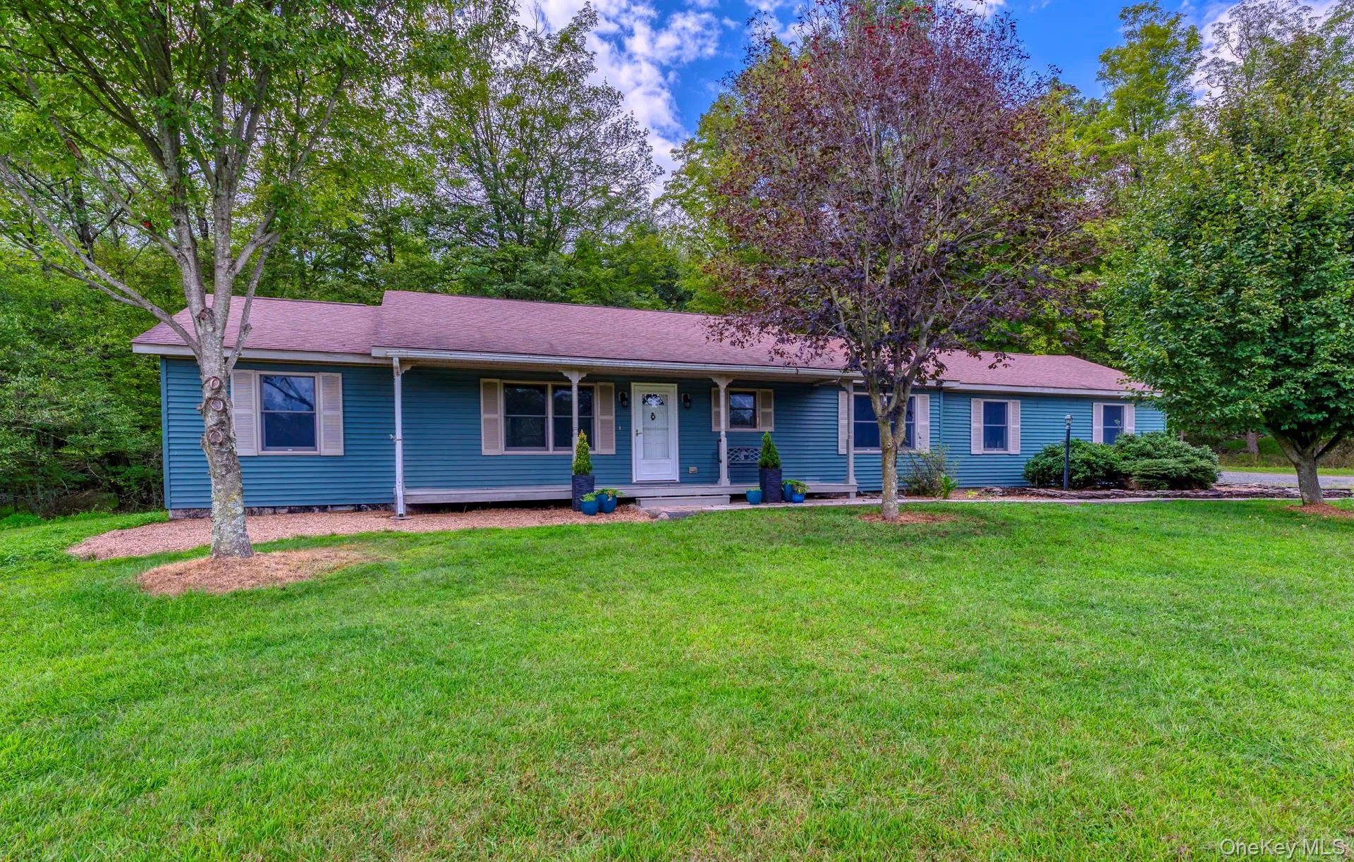 Ranch-style house with covered porch, a front yard, and roof with shingles Ranch-style house with covered porch, a front yard, and roof with shingles