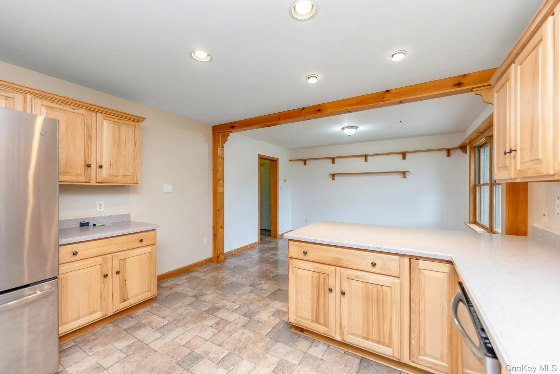 Kitchen with appliances with stainless steel finishes, light brown cabinetry, light countertops, a peninsula, and recessed lighting Kitchen with appliances with stainless steel finishes, light brown cabinetry, light countertops, a peninsula, and recessed lighting