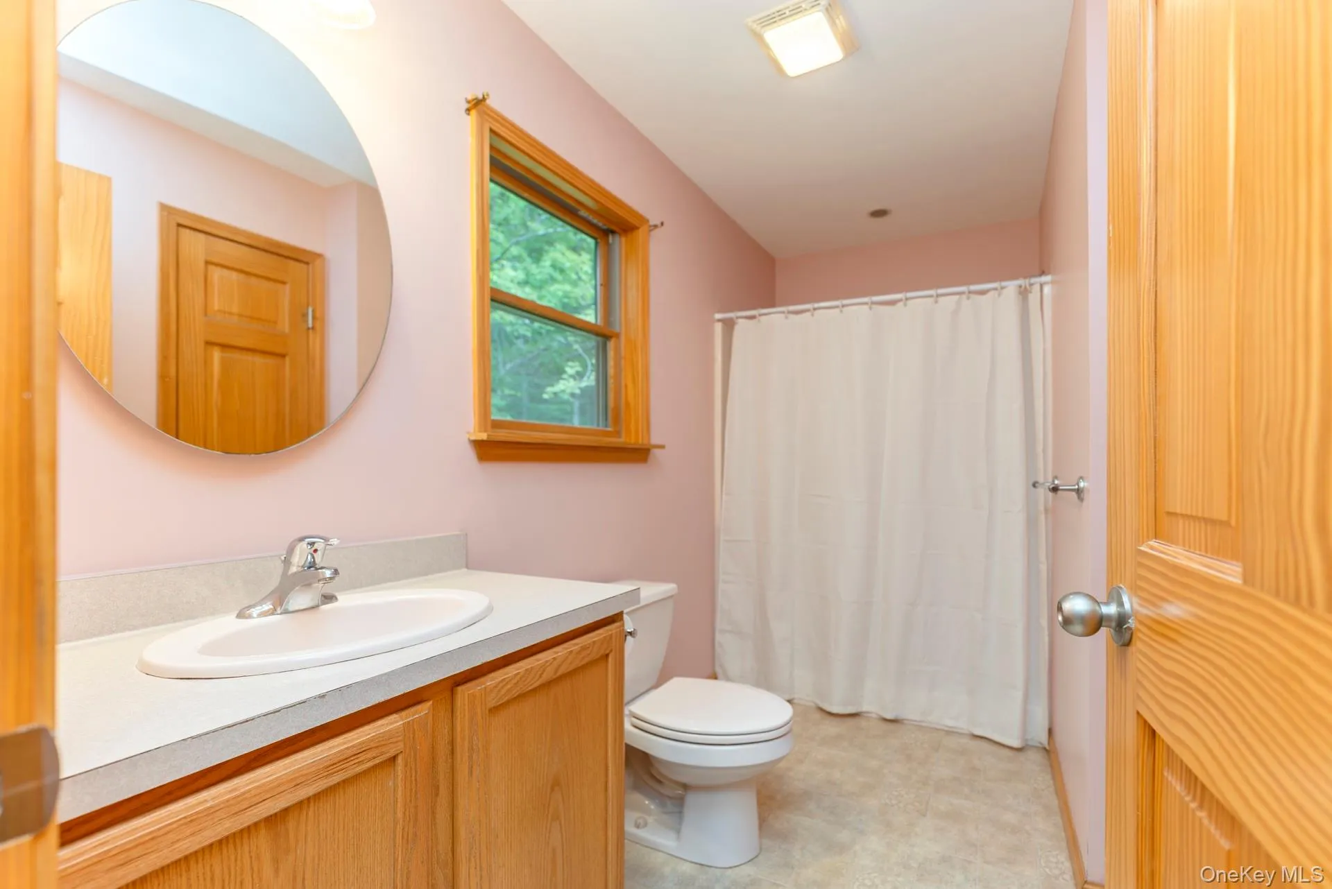 Bathroom with vanity, toilet, and curtained shower Bathroom with vanity, toilet, and curtained shower