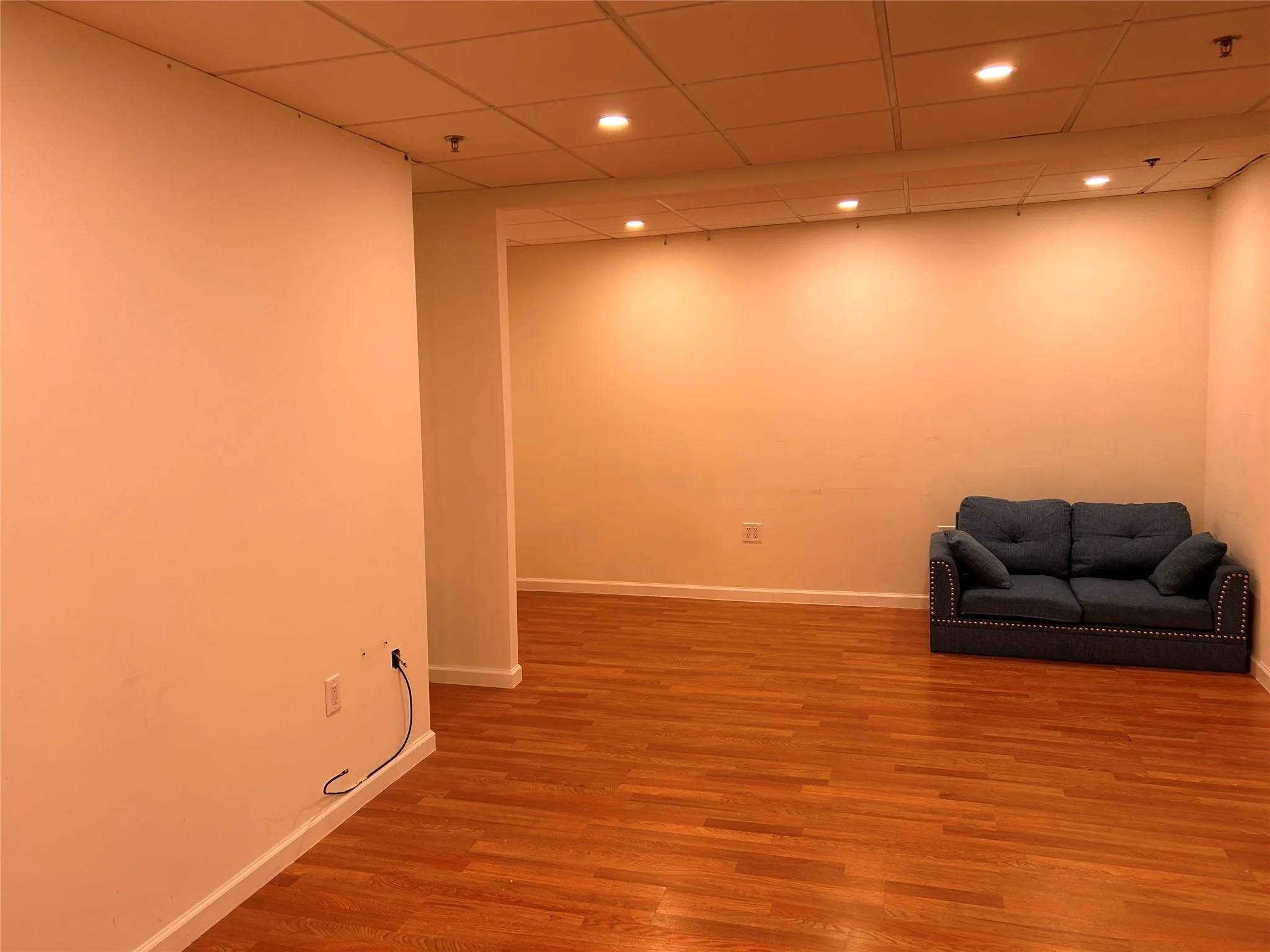 Unfurnished room featuring baseboards, wood finished floors, recessed lighting, and a drop ceiling Unfurnished room featuring baseboards, wood finished floors, recessed lighting, and a drop ceiling