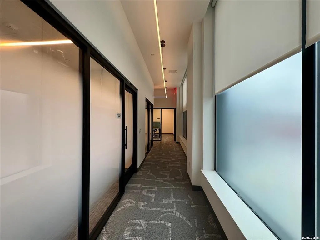 Hall featuring dark colored carpet Hall featuring dark colored carpet