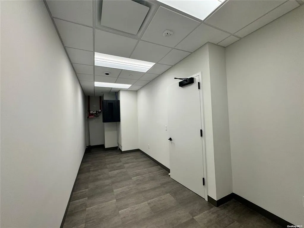 Hall featuring a paneled ceiling and baseboards Hall featuring a paneled ceiling and baseboards
