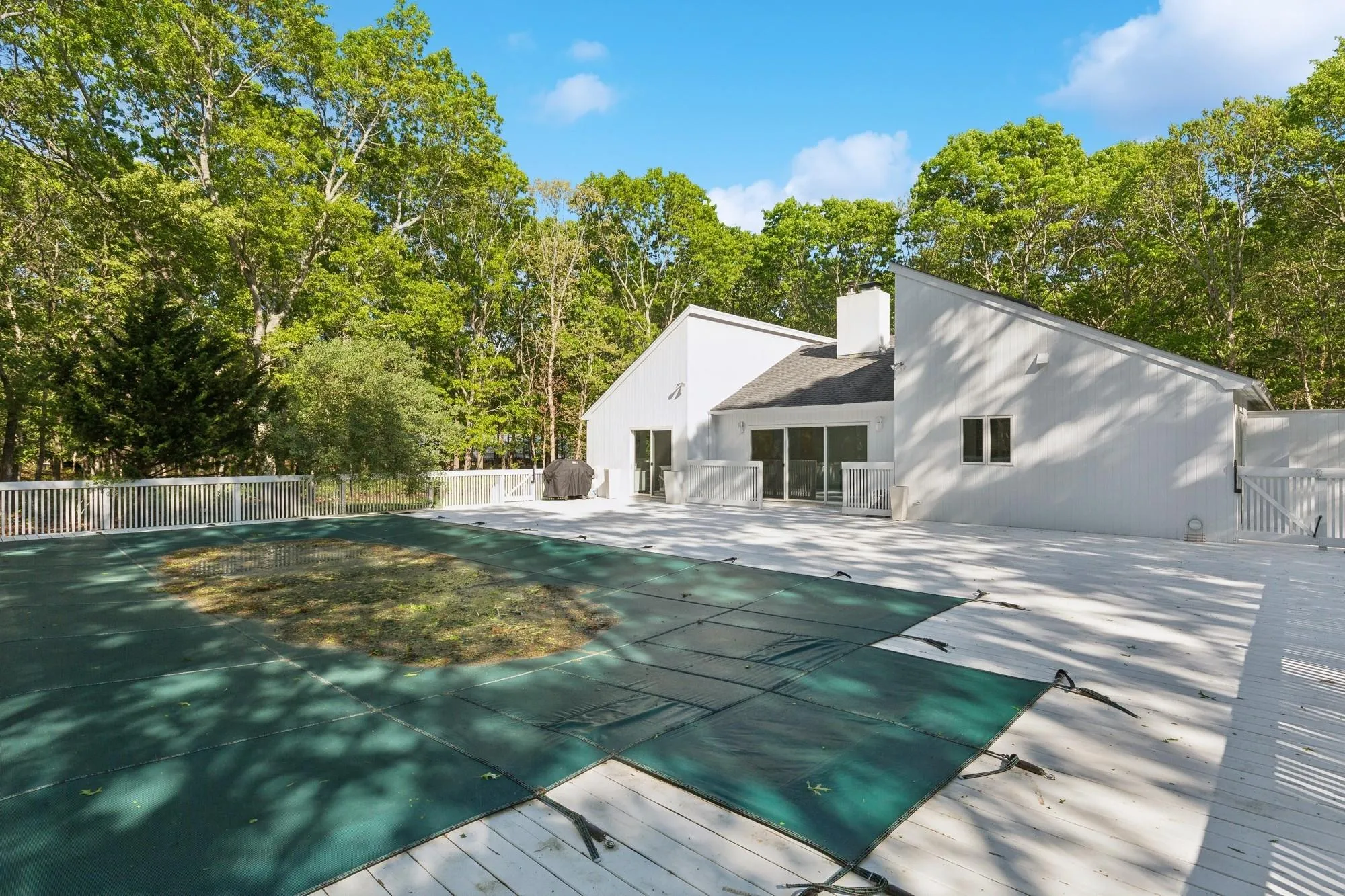 View of pool featuring a gate and a patio area View of pool featuring a gate and a patio area