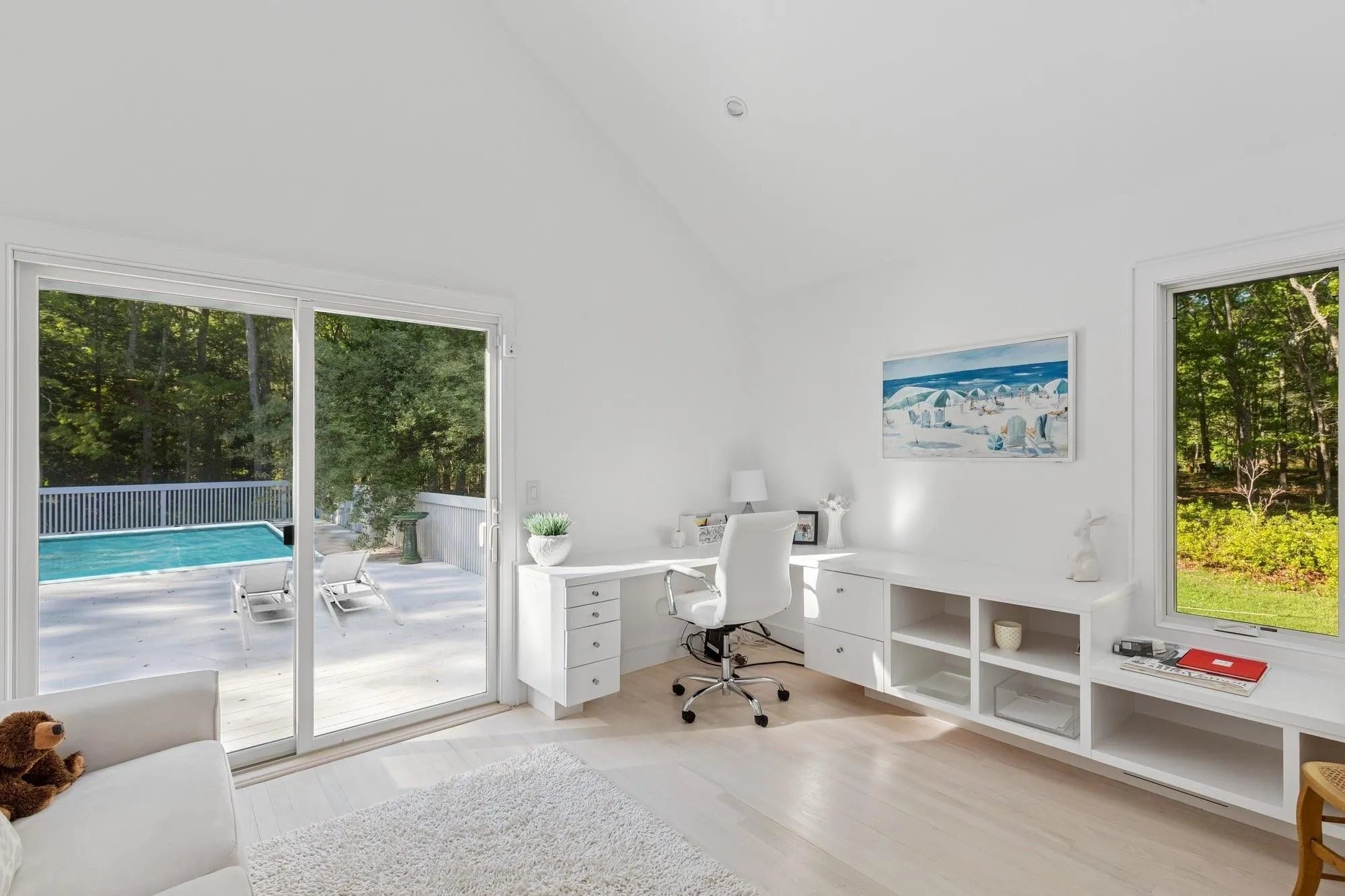Office area featuring high vaulted ceiling and light wood-style flooring Office area featuring high vaulted ceiling and light wood-style flooring