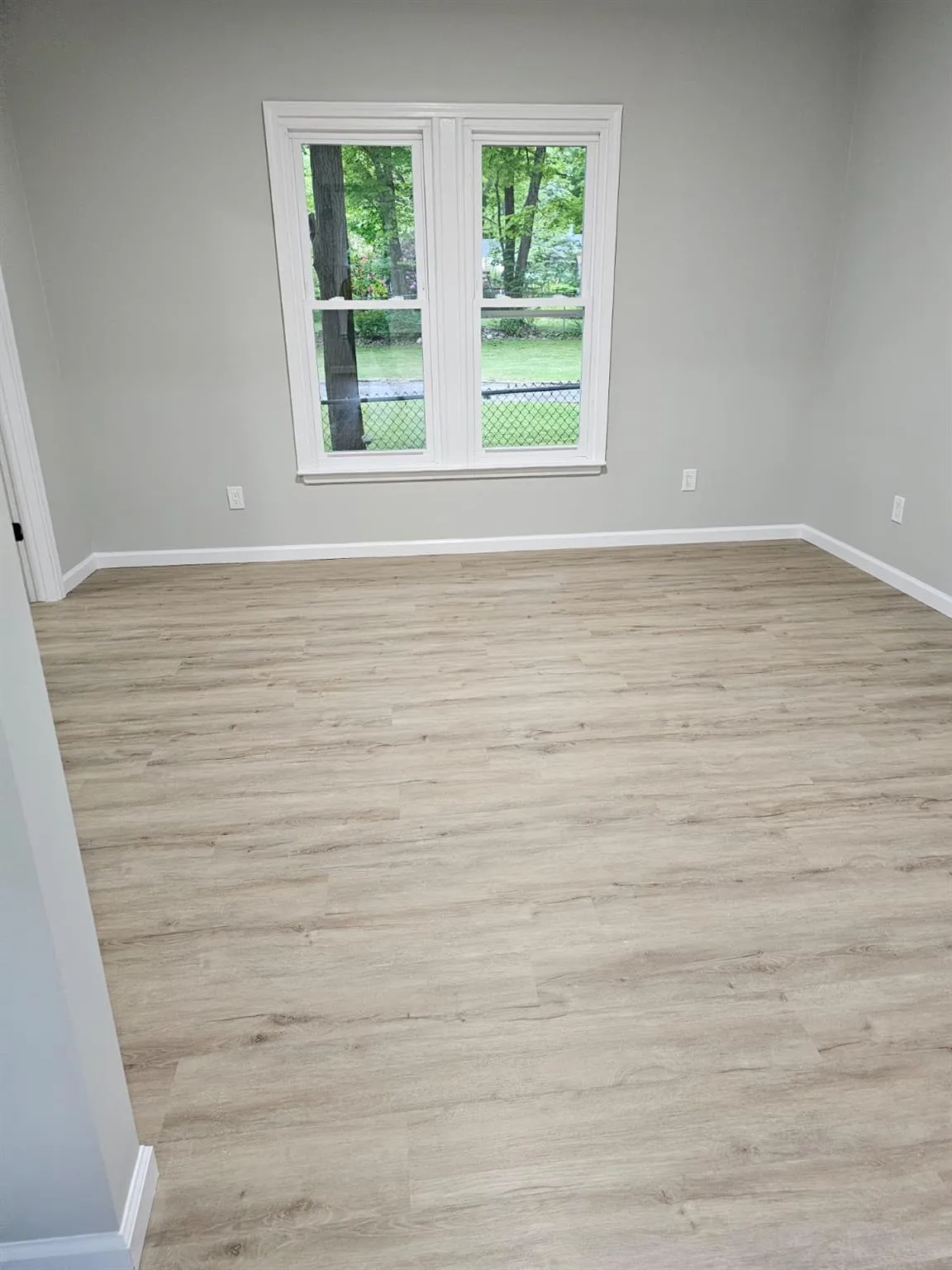 Unfurnished room with baseboards and light wood finished floors Unfurnished room with baseboards and light wood finished floors