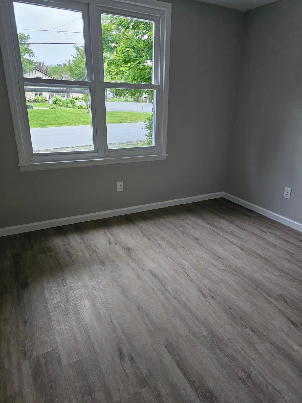 Unfurnished room featuring wood finished floors, plenty of natural light, and baseboards Unfurnished room featuring wood finished floors, plenty of natural light, and baseboards