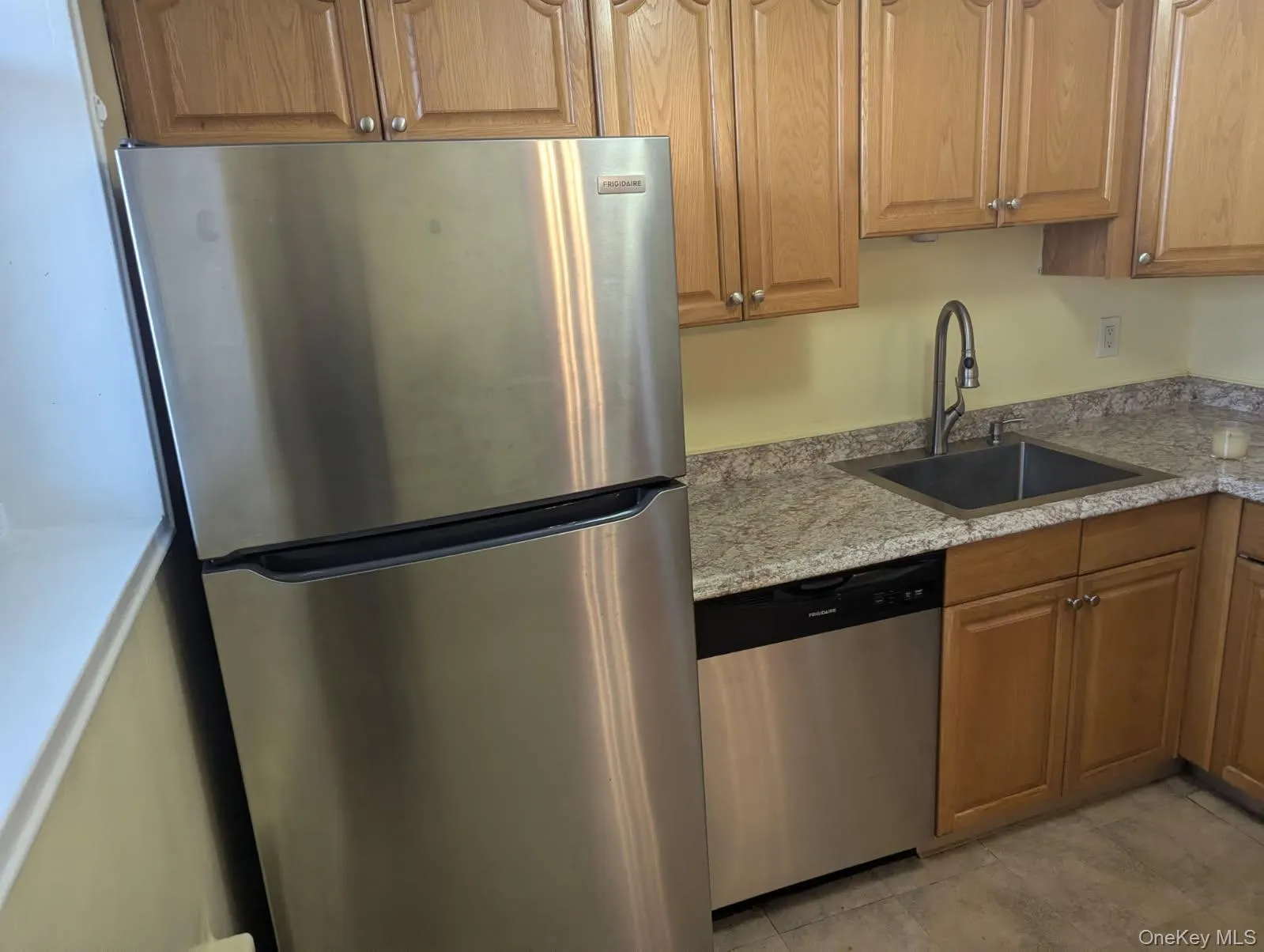 Kitchen featuring appliances with stainless steel finishes and light stone counters Kitchen featuring appliances with stainless steel finishes and light stone counters