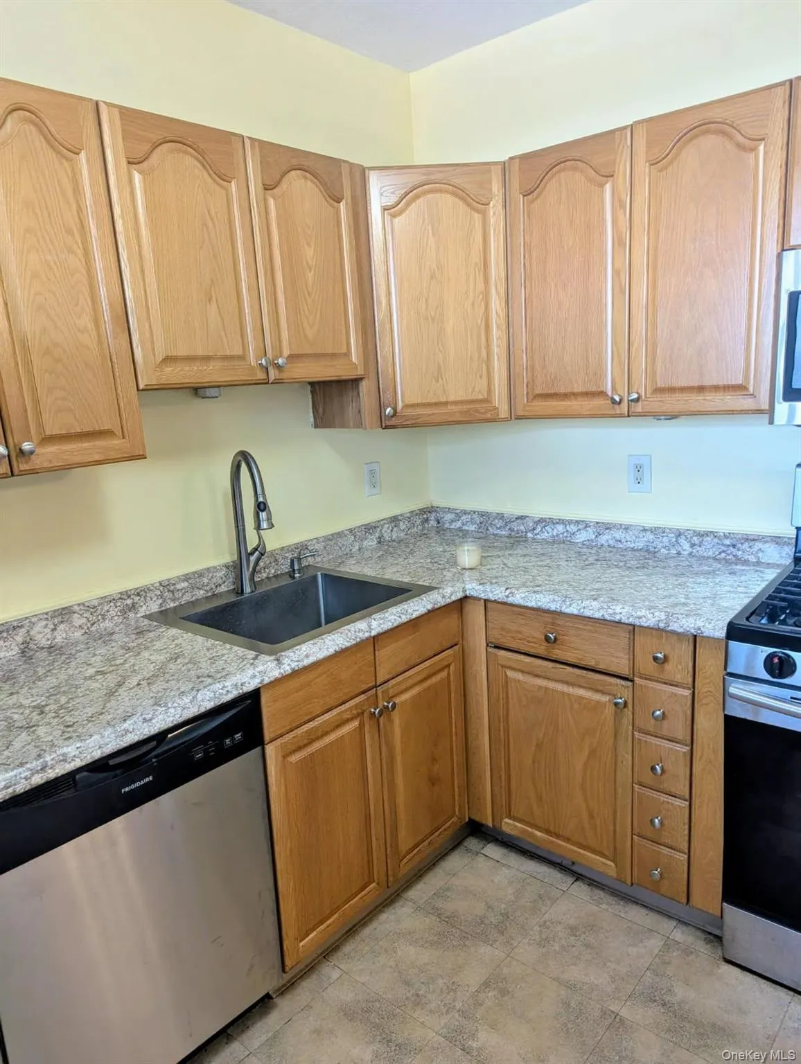 Kitchen with stainless steel appliances, light stone countertops, and light stone finish floors Kitchen with stainless steel appliances, light stone countertops, and light stone finish floors