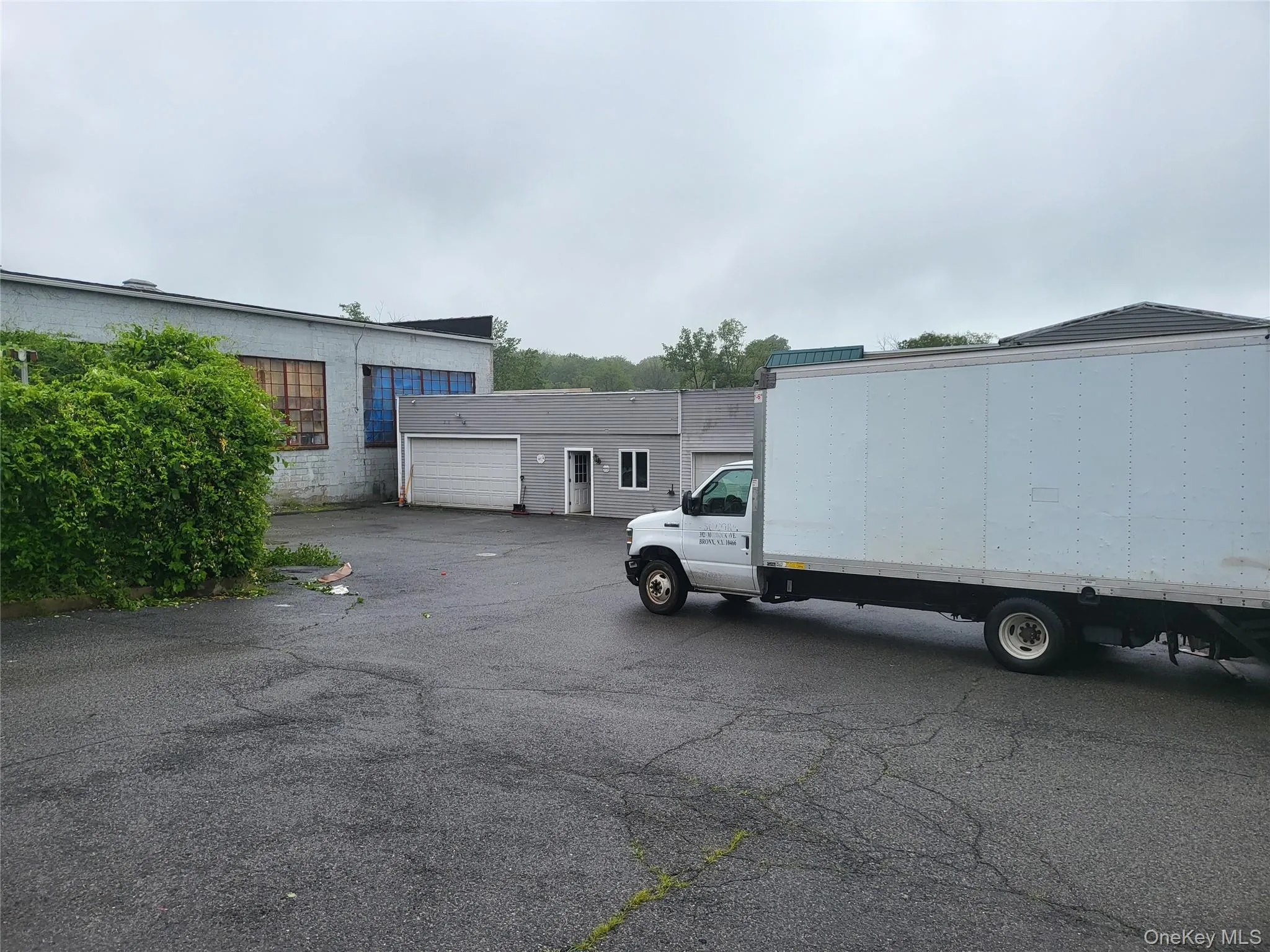 View of parking featuring a garage View of parking featuring a garage