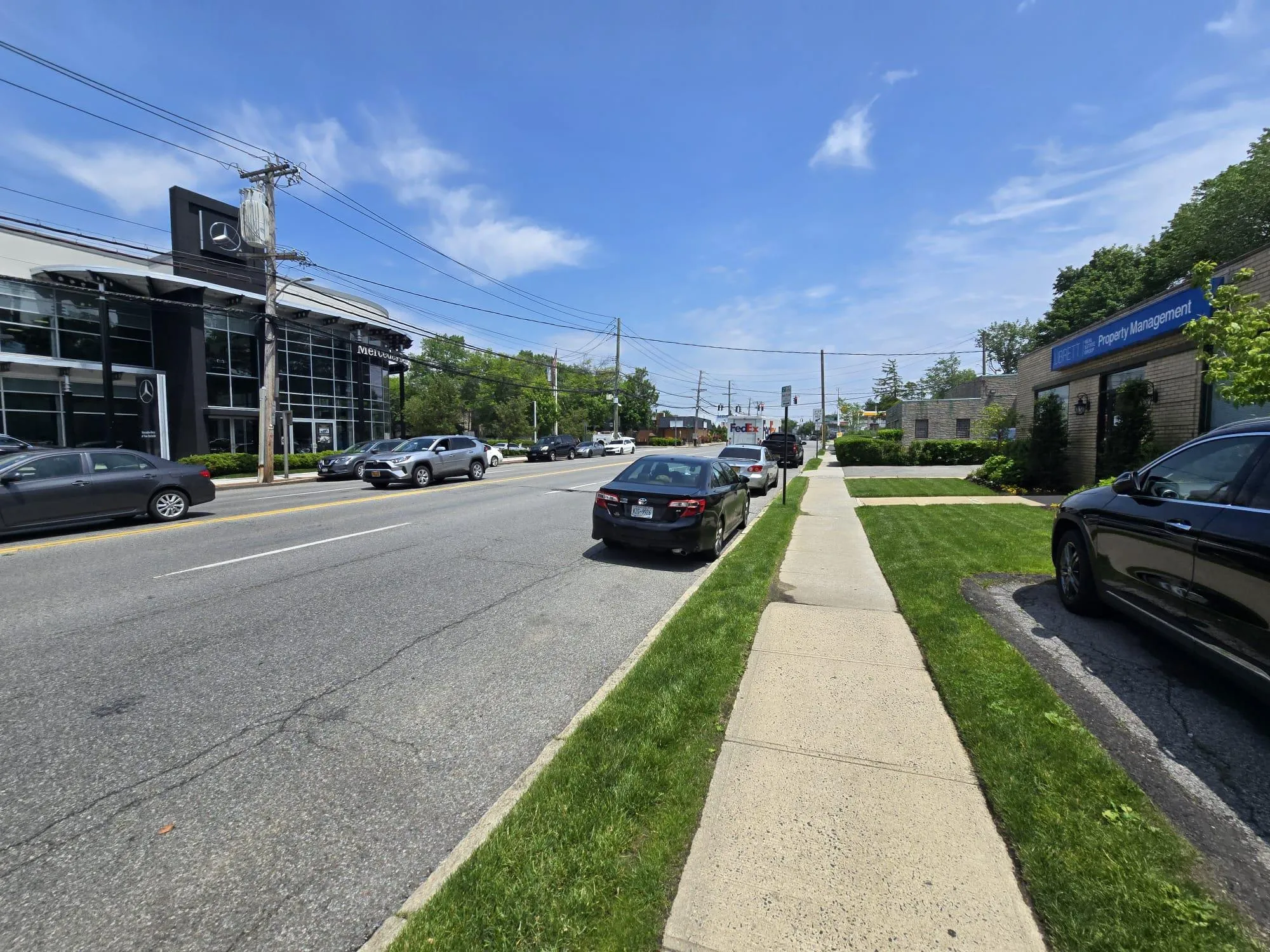 View of asphalt road with curbs and sidewalks View of asphalt road with curbs and sidewalks