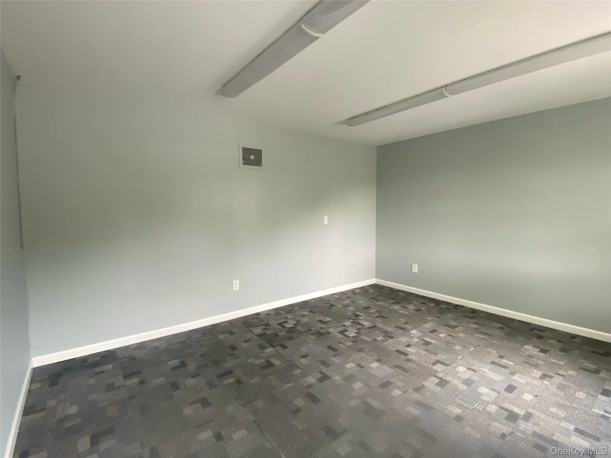 Empty room featuring baseboards and dark colored carpet Empty room featuring baseboards and dark colored carpet