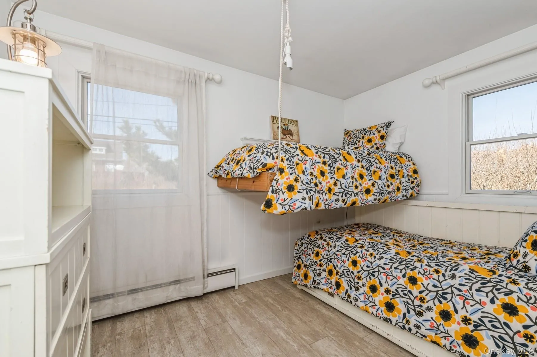 Bedroom featuring a baseboard heating unit and light wood-style floors Bedroom featuring a baseboard heating unit and light wood-style floors