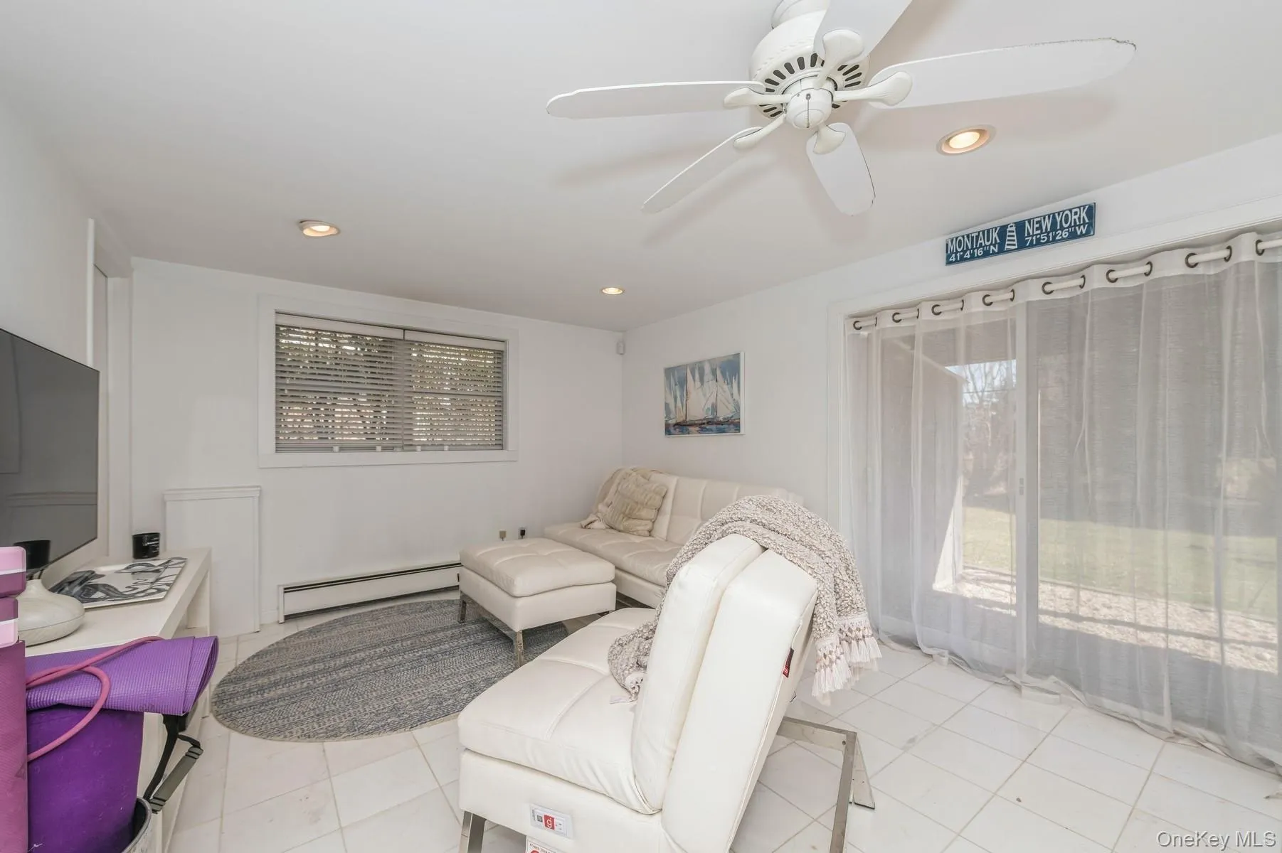 Living area featuring baseboard heating, a ceiling fan, light tile patterned flooring, recessed lighting, and healthy amount of natural light Living area featuring baseboard heating, a ceiling fan, light tile patterned flooring, recessed lighting, and healthy amount of natural light