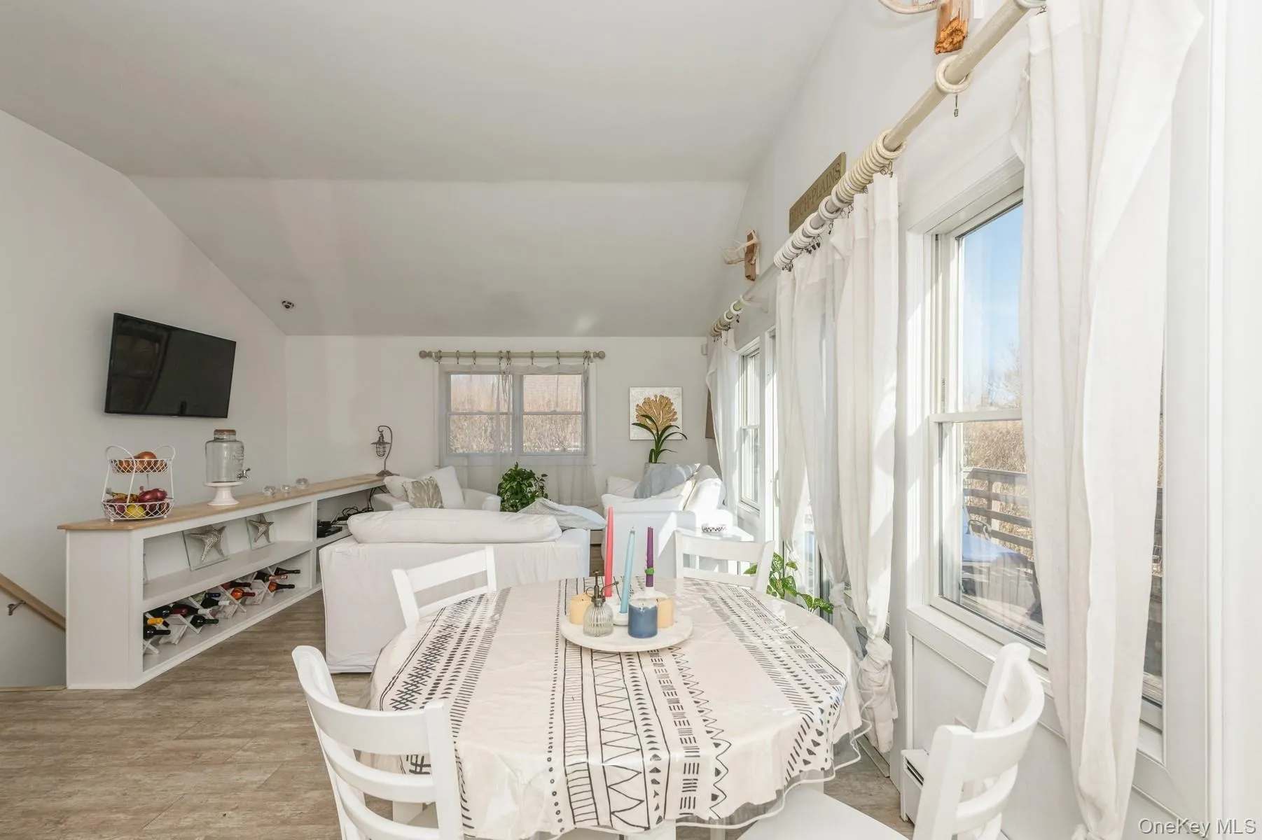 Dining room with plenty of natural light, vaulted ceiling, and light wood-style flooring Dining room with plenty of natural light, vaulted ceiling, and light wood-style flooring