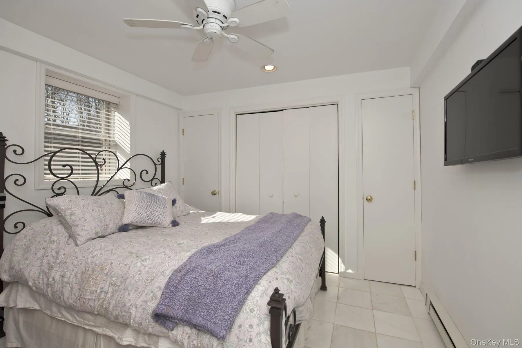 Bedroom with baseboard heating, recessed lighting, a closet, and a ceiling fan Bedroom with baseboard heating, recessed lighting, a closet, and a ceiling fan