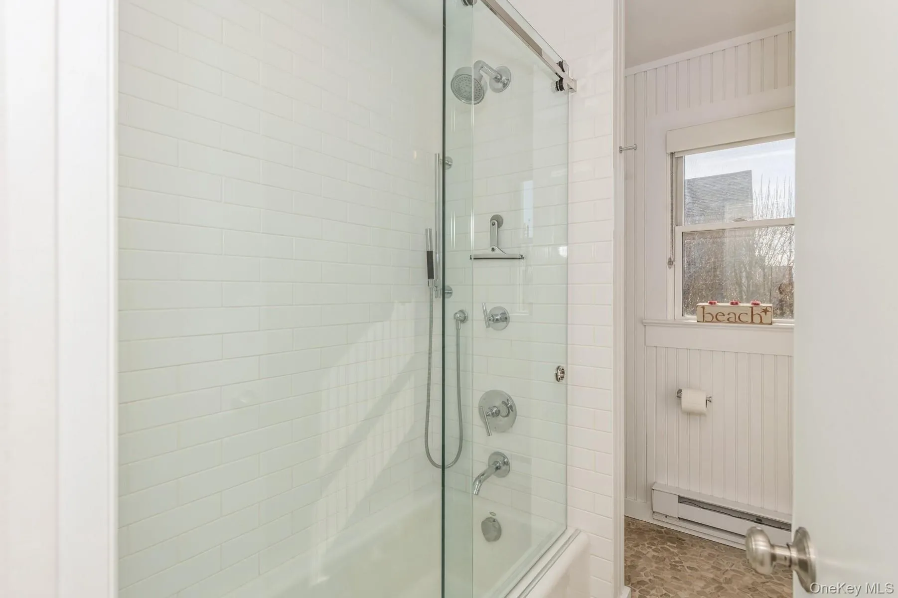 Full bath featuring baseboard heating and bath / shower combo with glass door Full bath featuring baseboard heating and bath / shower combo with glass door