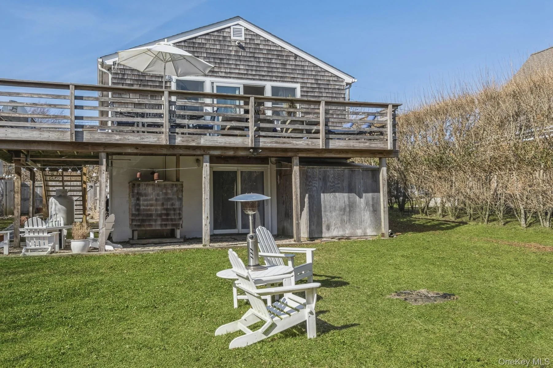 Rear view of house featuring a deck, a lawn, and stairs Rear view of house featuring a deck, a lawn, and stairs
