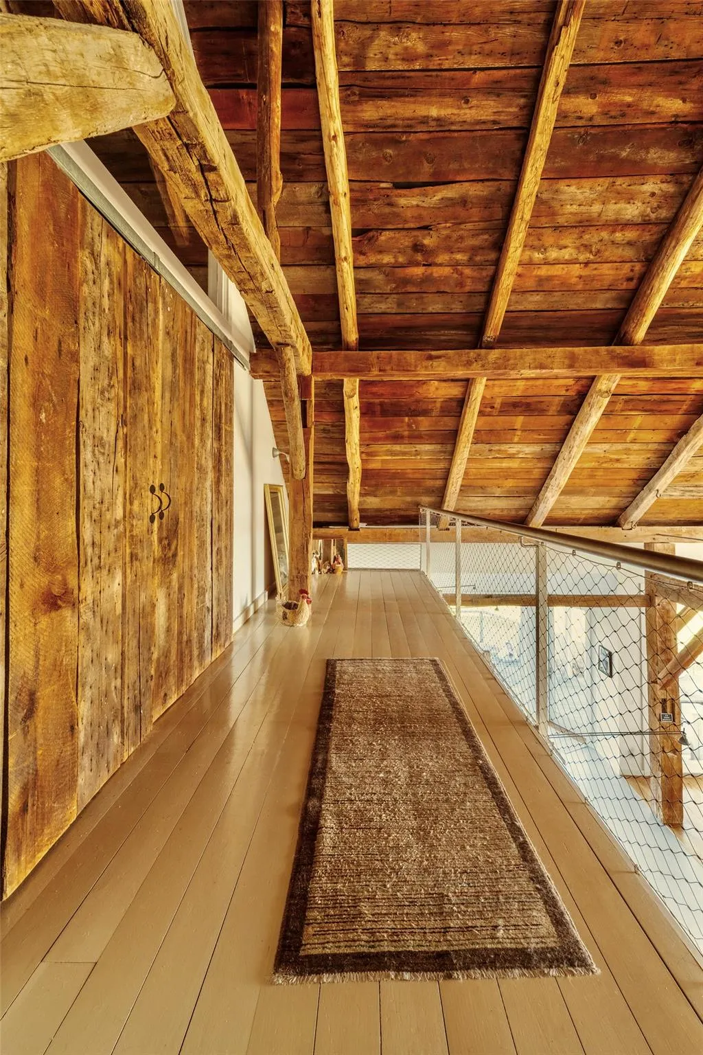 Hallway featuring wooden ceiling with exposed beams, wood-type flooring, and wood walls Hallway featuring wooden ceiling with exposed beams, wood-type flooring, and wood walls