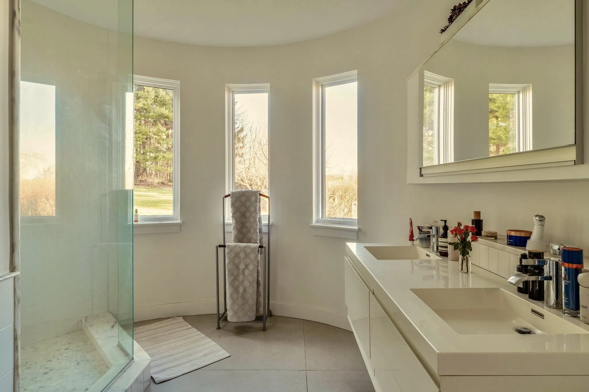 Bathroom featuring double vanity, a shower with shower door, baseboards, and tile patterned floors Bathroom featuring double vanity, a shower with shower door, baseboards, and tile patterned floors