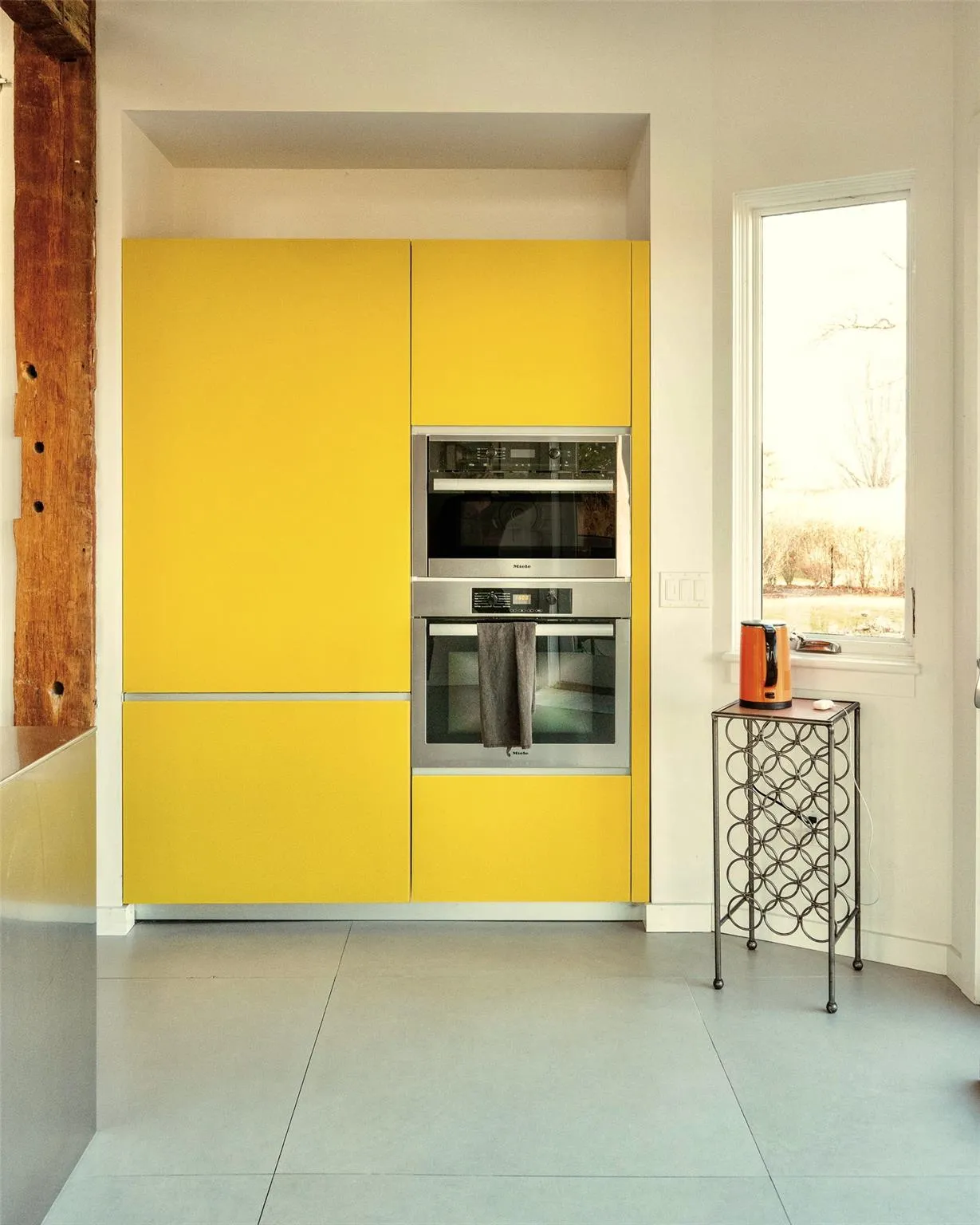 Kitchen featuring double oven, yellow cabinetry, cream cabinets, and tile patterned flooring Kitchen featuring double oven, yellow cabinetry, cream cabinets, and tile patterned flooring