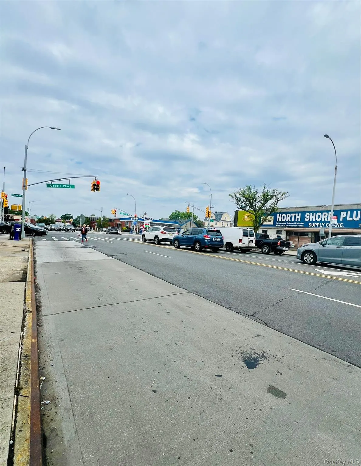 View of asphalt road with street lights, curbs, and traffic lights View of asphalt road with street lights, curbs, and traffic lights
