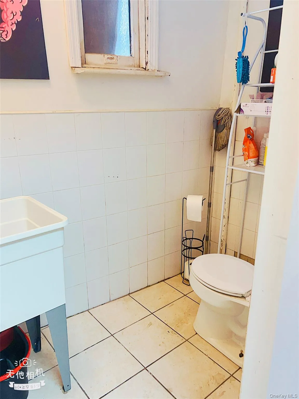 Half bathroom with tile walls, toilet, tile patterned flooring, vanity, and wainscoting Half bathroom with tile walls, toilet, tile patterned flooring, vanity, and wainscoting