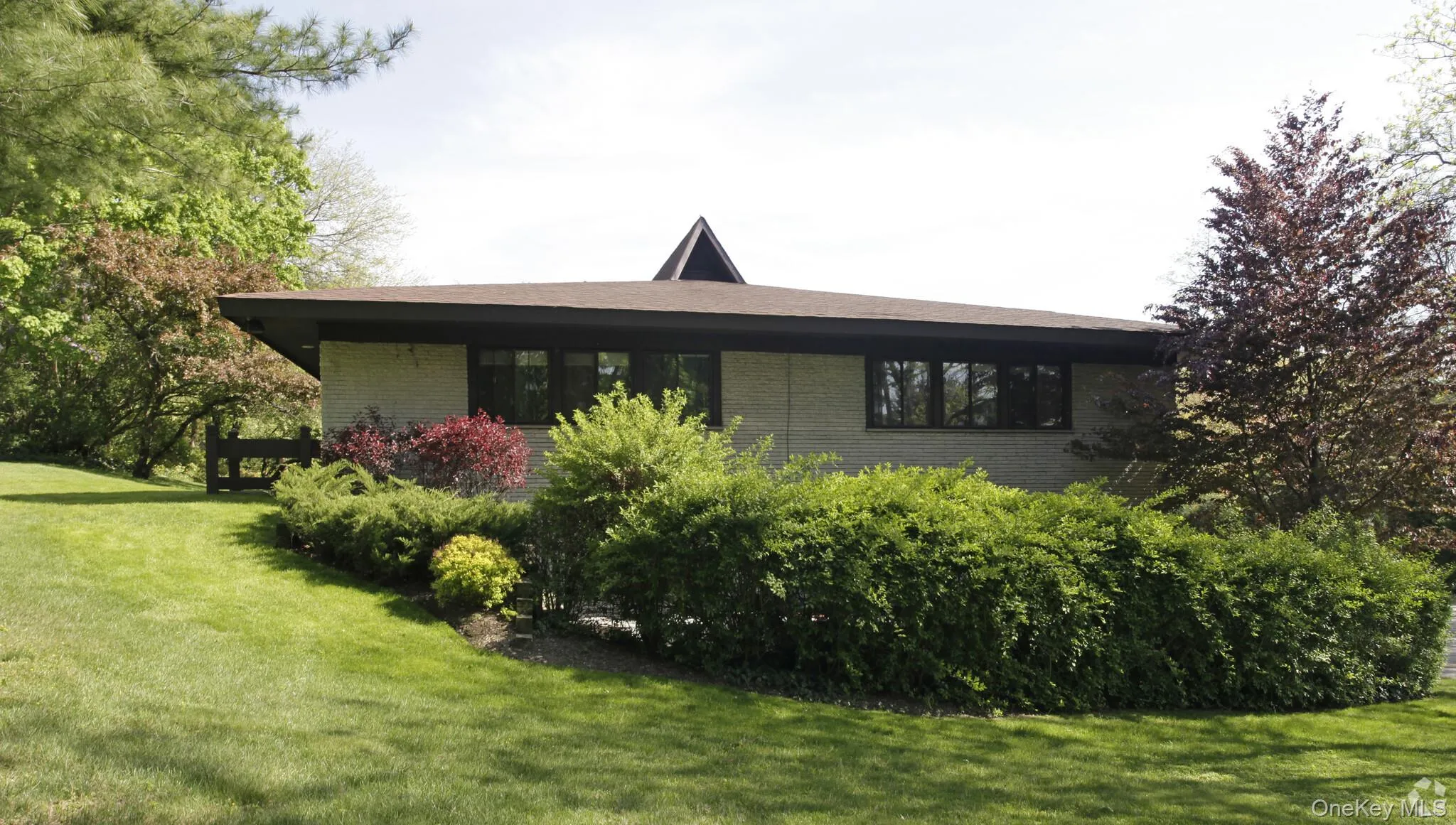View of property exterior featuring brick siding and a yard View of property exterior featuring brick siding and a yard