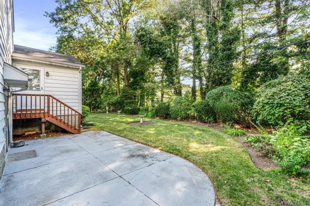 View of green lawn with a patio area and view of wooded area View of green lawn with a patio area and view of wooded area