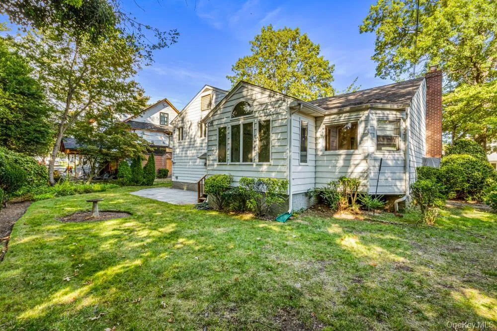Back of house with a patio area, a chimney, and a lawn Back of house with a patio area, a chimney, and a lawn