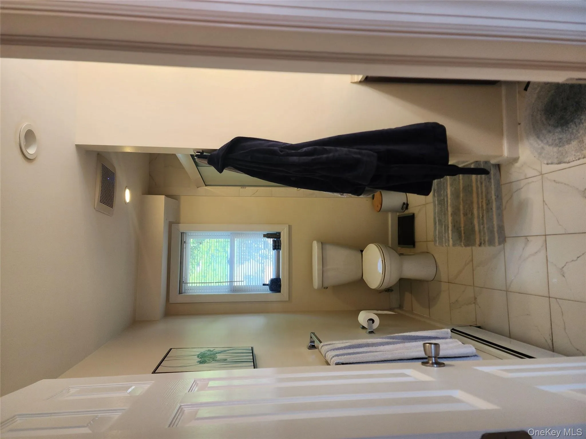 Bathroom featuring a baseboard radiator, toilet, marble finish flooring, baseboards, and recessed lighting Bathroom featuring a baseboard radiator, toilet, marble finish flooring, baseboards, and recessed lighting