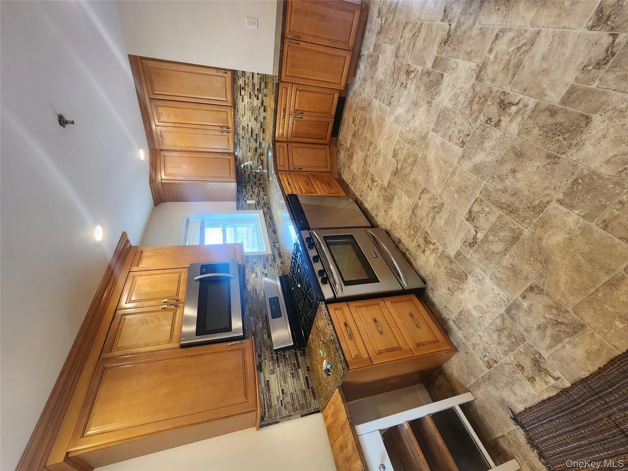 Kitchen featuring range, dishwashing machine, stone tile floors, backsplash, and recessed lighting Kitchen featuring range, dishwashing machine, stone tile floors, backsplash, and recessed lighting