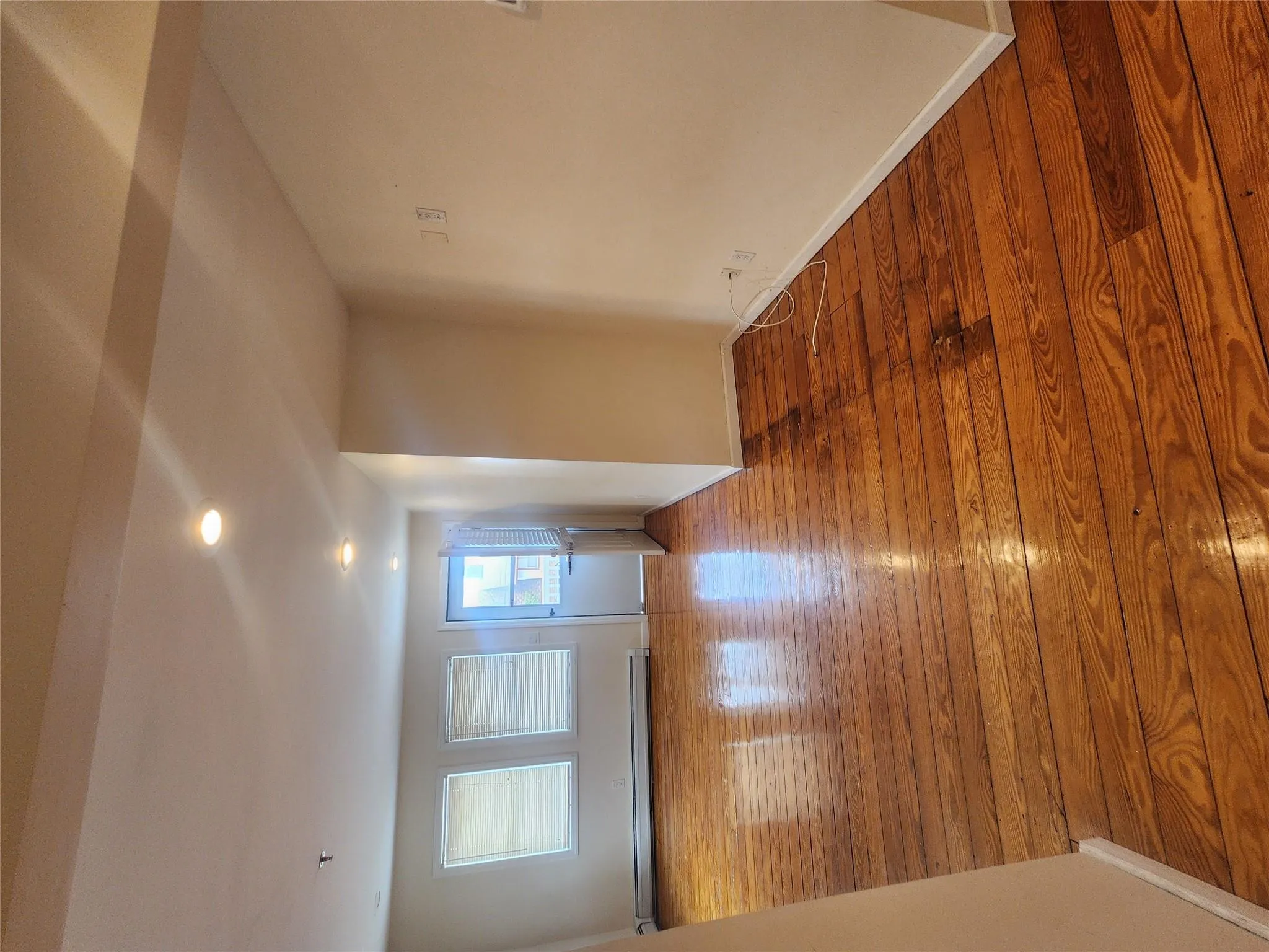 Empty room featuring baseboard heating, recessed lighting, and wood finished floors Empty room featuring baseboard heating, recessed lighting, and wood finished floors