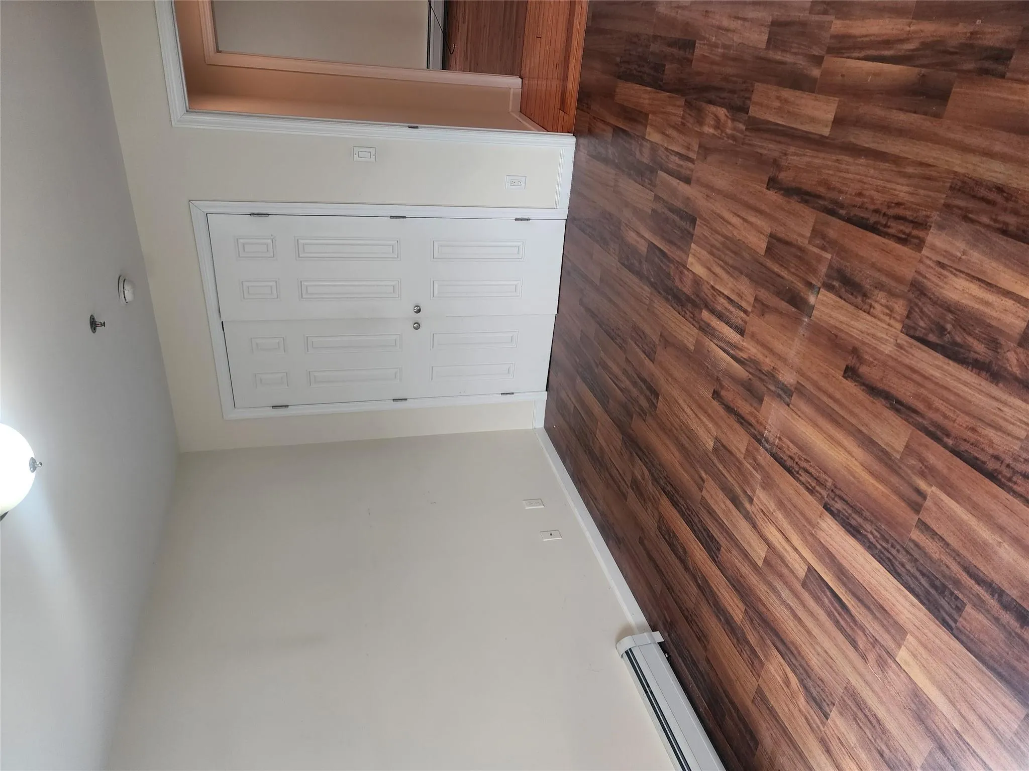 Unfurnished bedroom with a closet, dark wood finished floors, baseboard heating, and a baseboard heating unit Unfurnished bedroom with a closet, dark wood finished floors, baseboard heating, and a baseboard heating unit