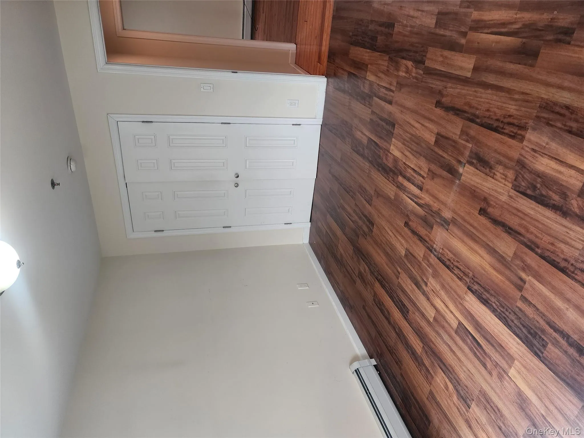 Unfurnished bedroom with a closet, dark wood finished floors, baseboard heating, and a baseboard heating unit Unfurnished bedroom with a closet, dark wood finished floors, baseboard heating, and a baseboard heating unit