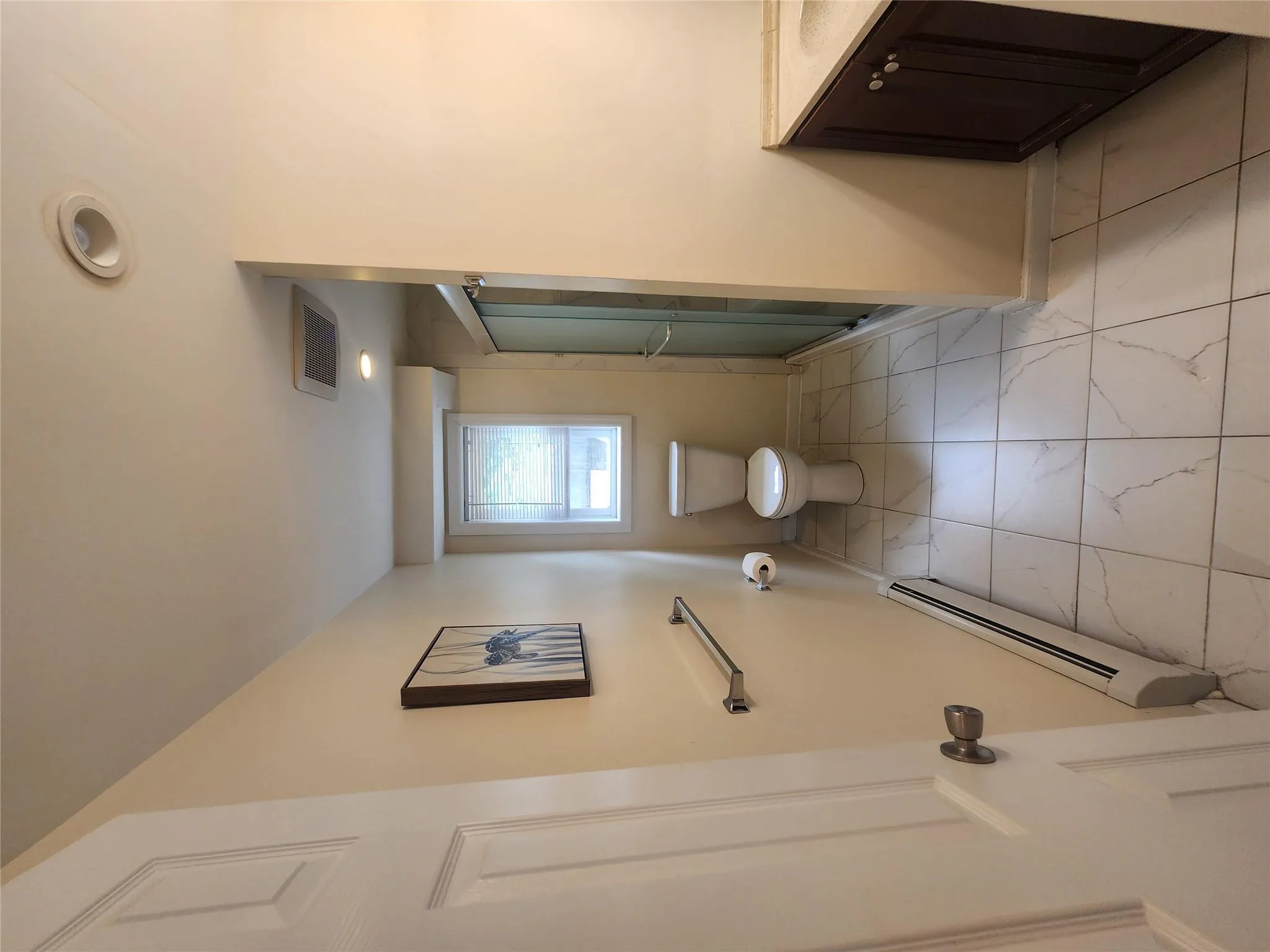 Bathroom with a baseboard heating unit, marble look tiles, vanity, and a shower stall Bathroom with a baseboard heating unit, marble look tiles, vanity, and a shower stall