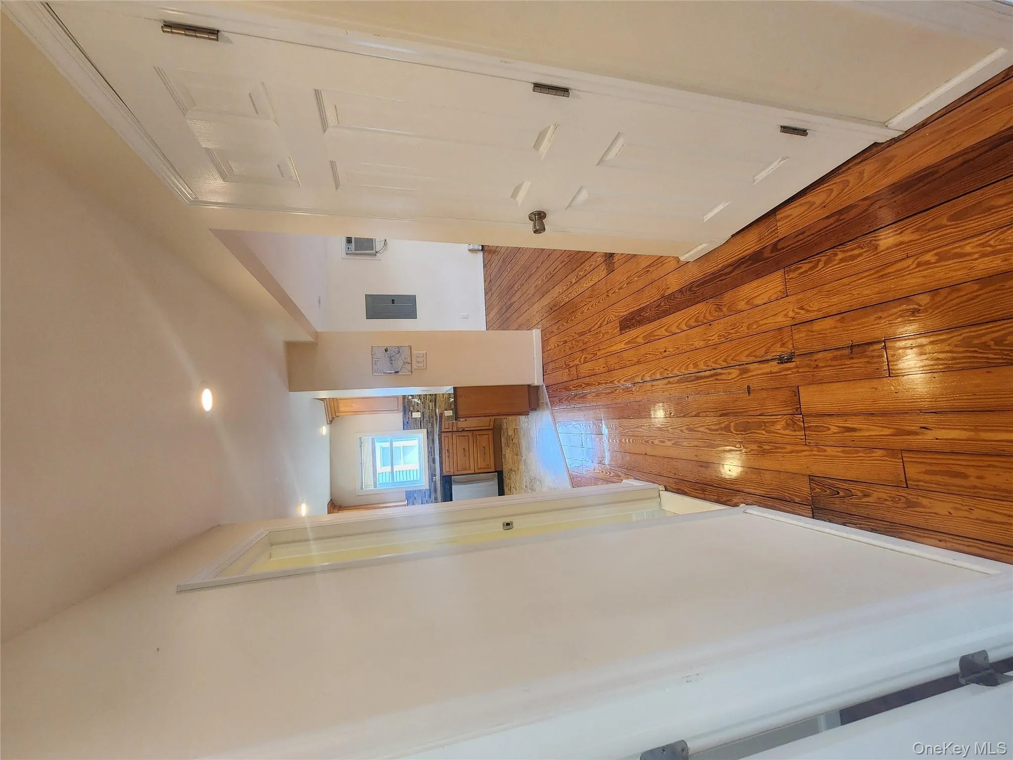 Hall with electric panel, light wood-style flooring, recessed lighting, and a wall mounted air conditioner Hall with electric panel, light wood-style flooring, recessed lighting, and a wall mounted air conditioner